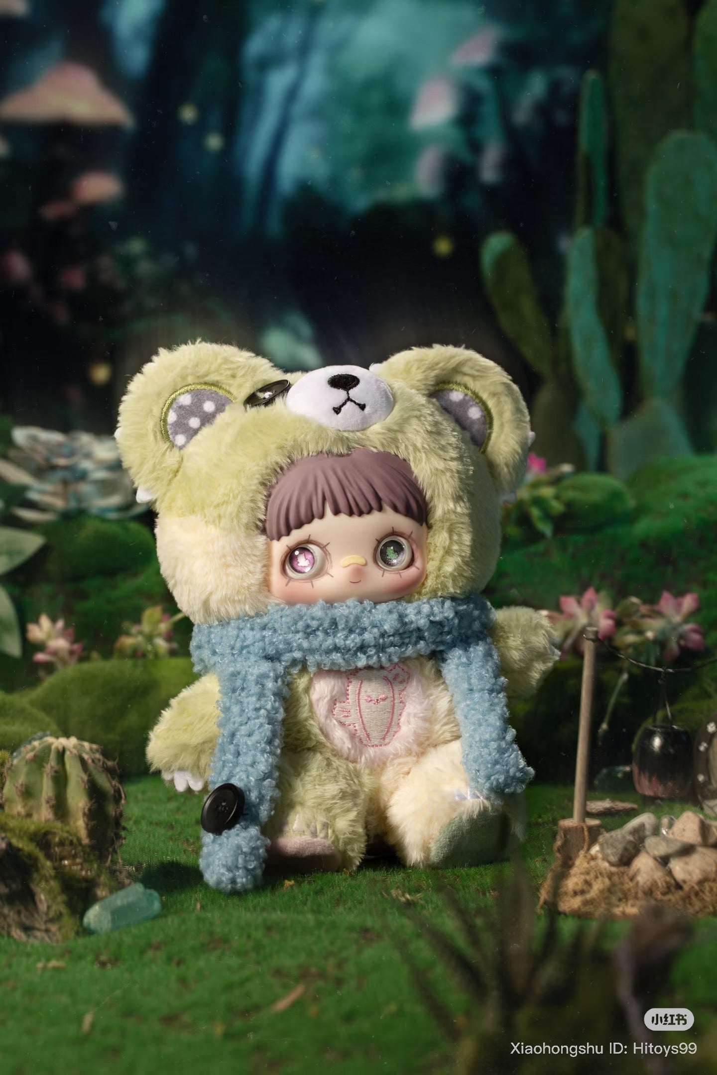 MayMei Symbiote Neverland Series Vinyl Keychain Plush Blind Box featuring a doll in a bear costume, set in a miniature diorama with tiny plants and a campfire.