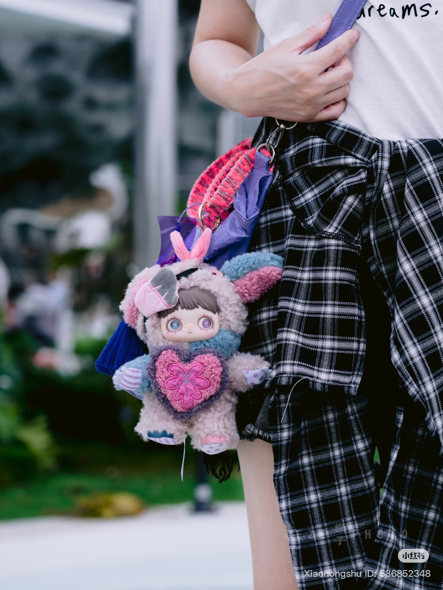MayMei Symbiote Neverland Series Vinyl Keychain Plush, featuring a pastel bunny suit doll with heart, attached to a purple-strapped shoulder bag.