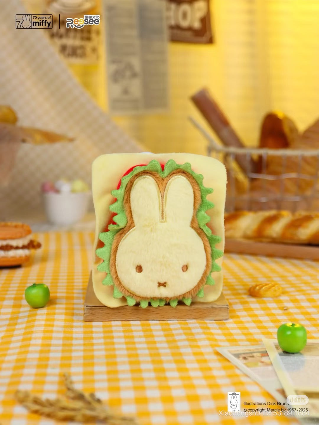 Miffy - Food Workshop Plush Keychain Blind Box features a Miffy sandwich toy with lettuce, tomato, and cheese details, propped among pastries and apples.