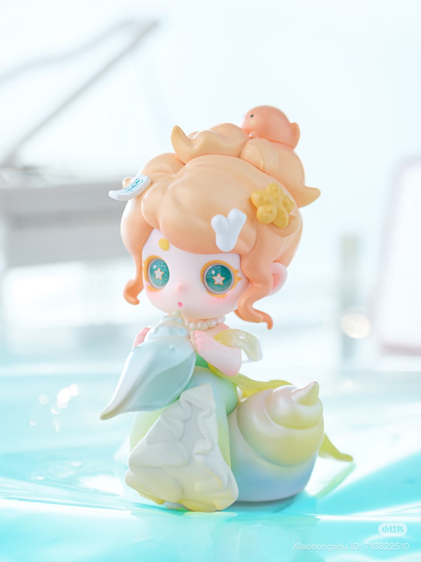 Keeno·Wish On The Sea Breeze Series Blind Box figure, chibi girl with sea-themed accessories, seated on a seashell, holding a conch shell.