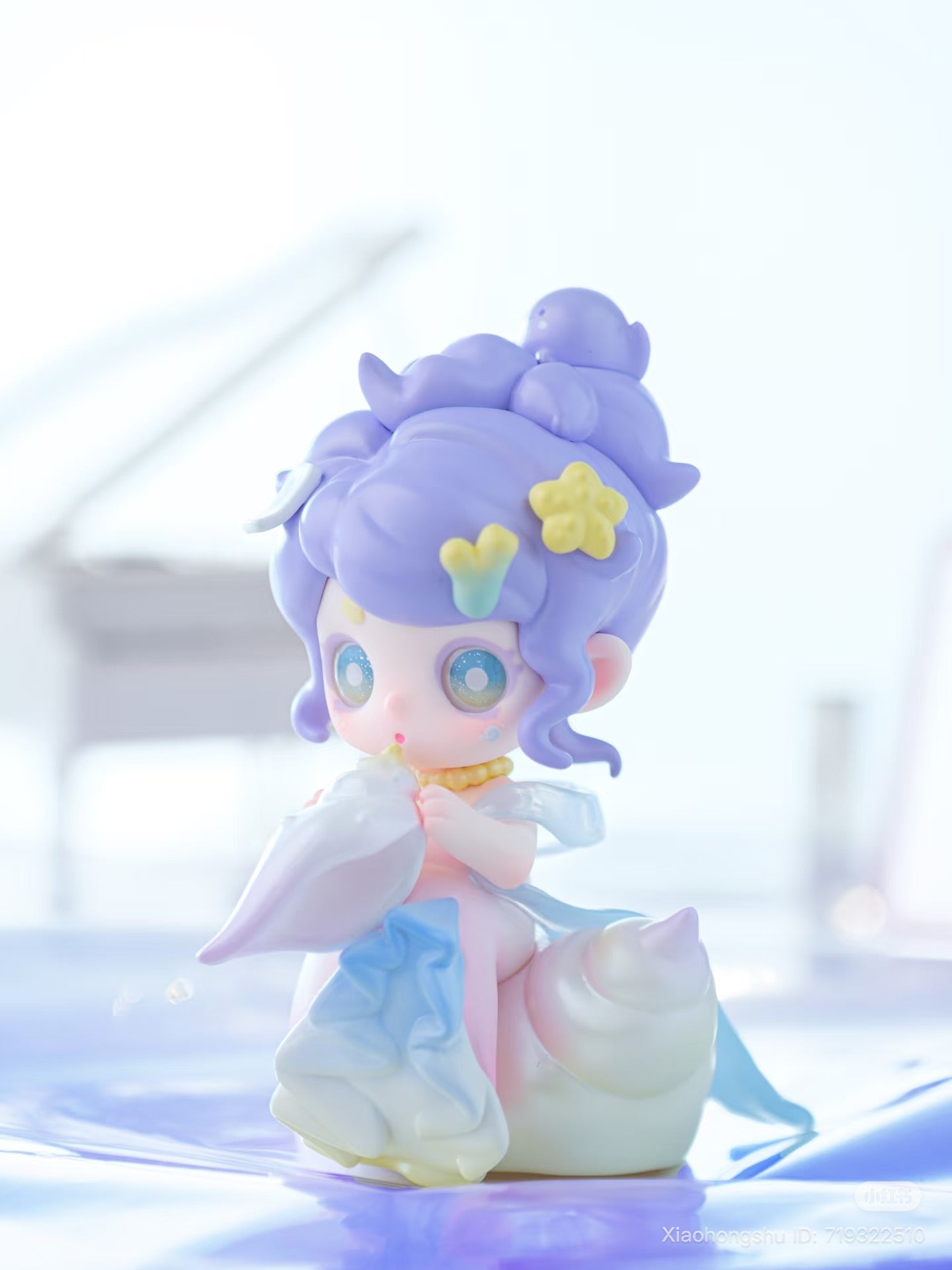 Keeno·Wish On The Sea Breeze figurine with purple hair, seated on a seashell, part of a blind box series from Strangecat Toys.