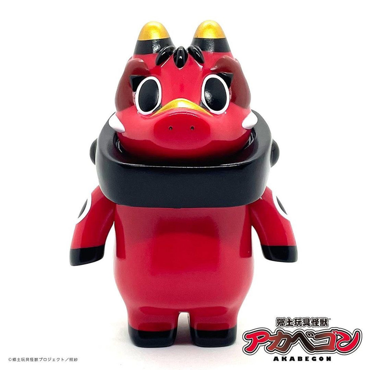 AKABEGON - Red by Teresa Chiba: A 12cm vinyl figure inspired by Akabeko, featuring horns, tusks, and a black collar, blending traditional Japanese and kaiju styles.