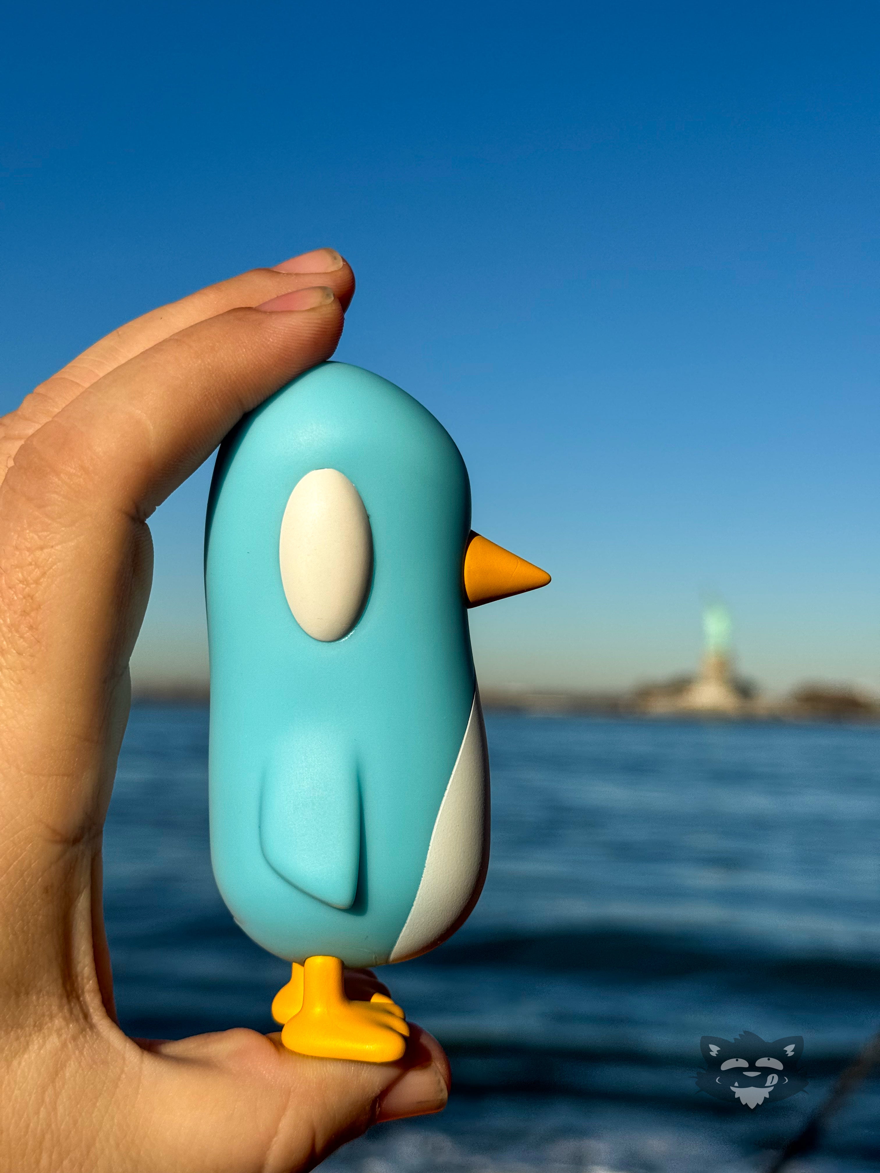 Toy penguin in hand, bird and cartoon details.