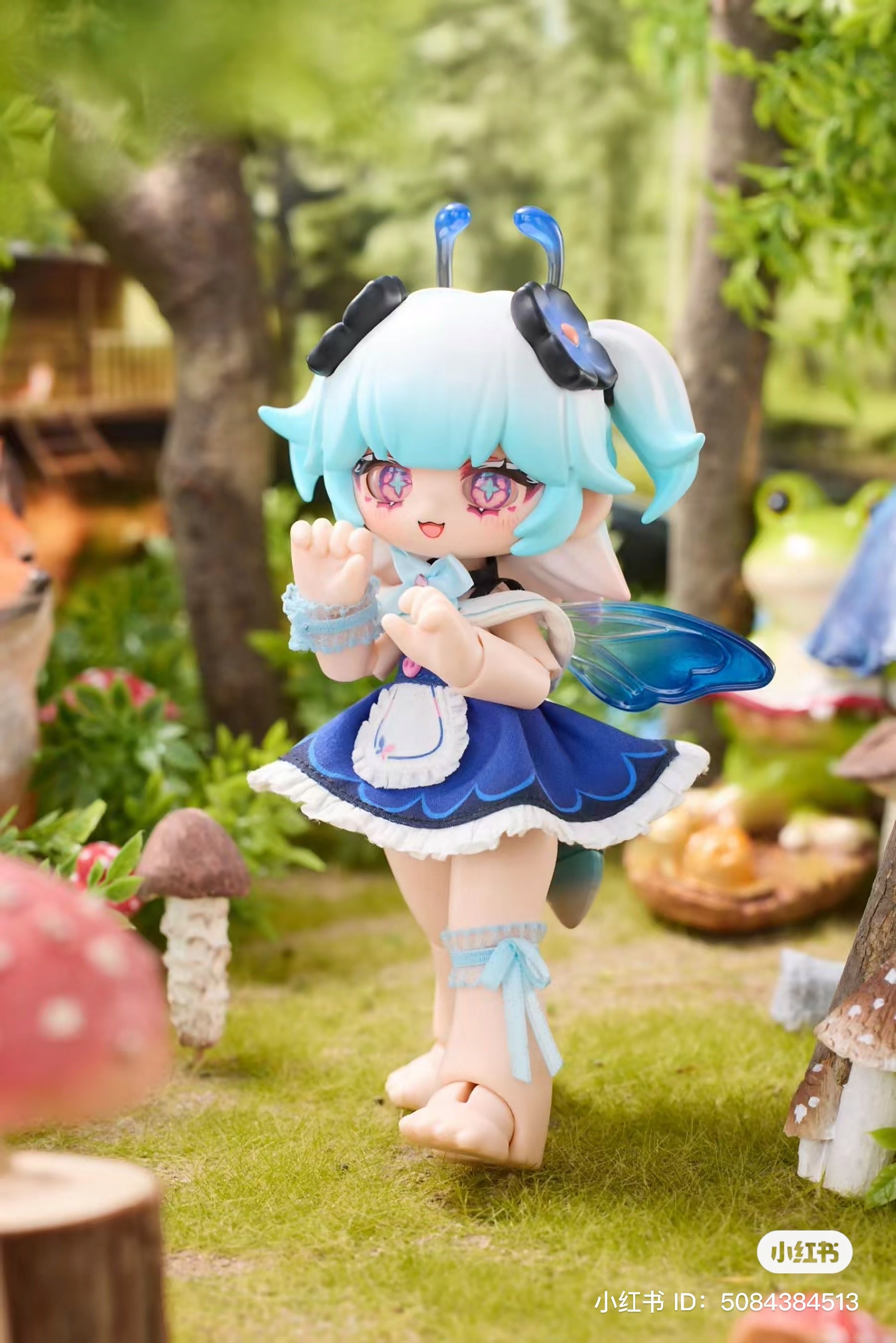 A toy figurine of a fairy in a garden and a doll with blue hair and wings from the Kukaka Insect Cafe BJD Blind Box Series.