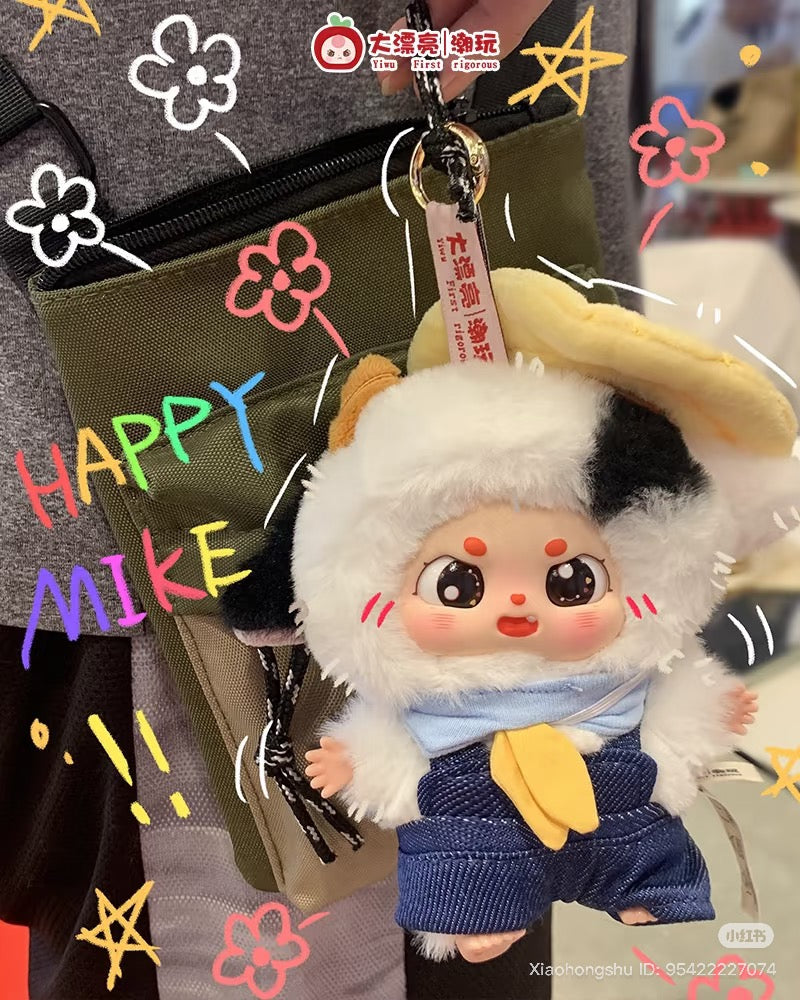 Baby Three - Little Fatty key-chain in fluffy animal costume with denim overalls, hanging from a khaki pouch, amid colorful doodles.