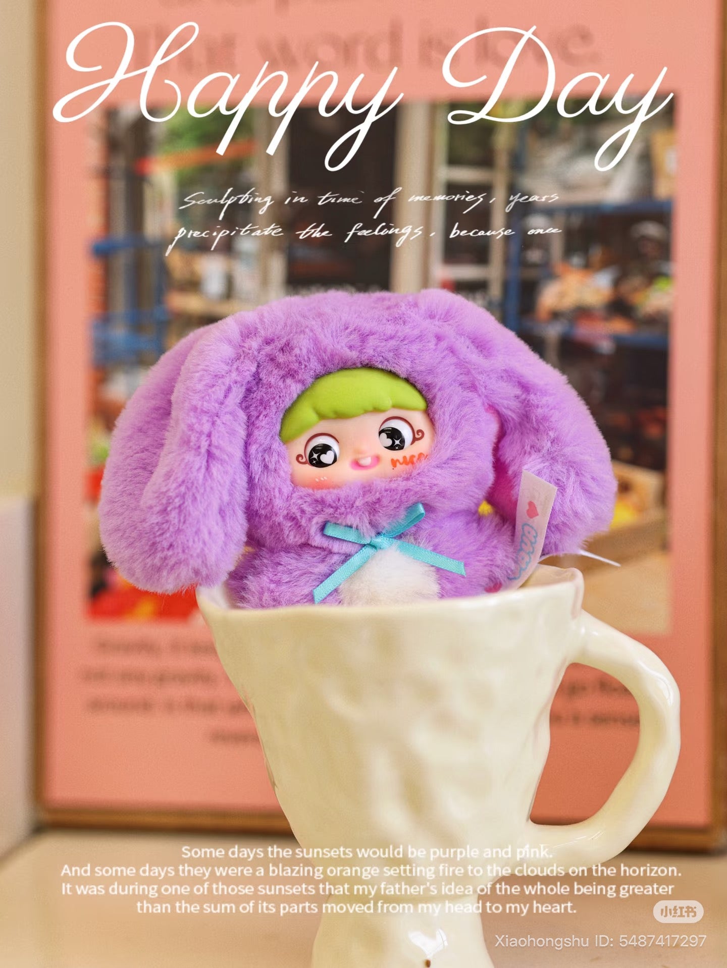 Baby Three doll in a fluffy bunny outfit sits in a mug, with Happy Day text and sunset inspiration, linked to YAYA's first birthday collection.