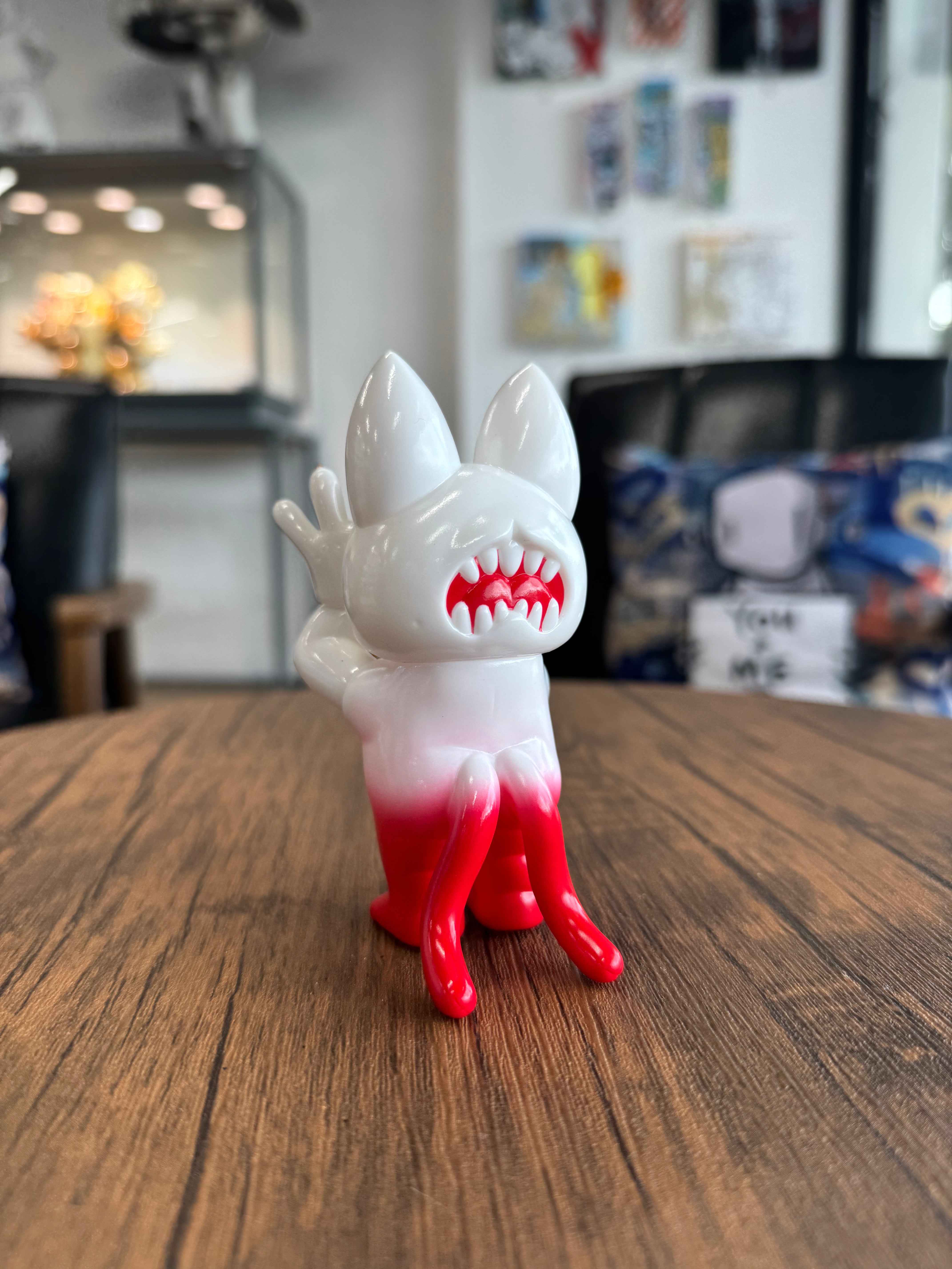 Onigiri Gripon SG by Grape Brain: A 11cm vinyl art toy with pointed ears, sharp red-tipped teeth, and tentacle-like legs, displayed on a wooden tabletop.