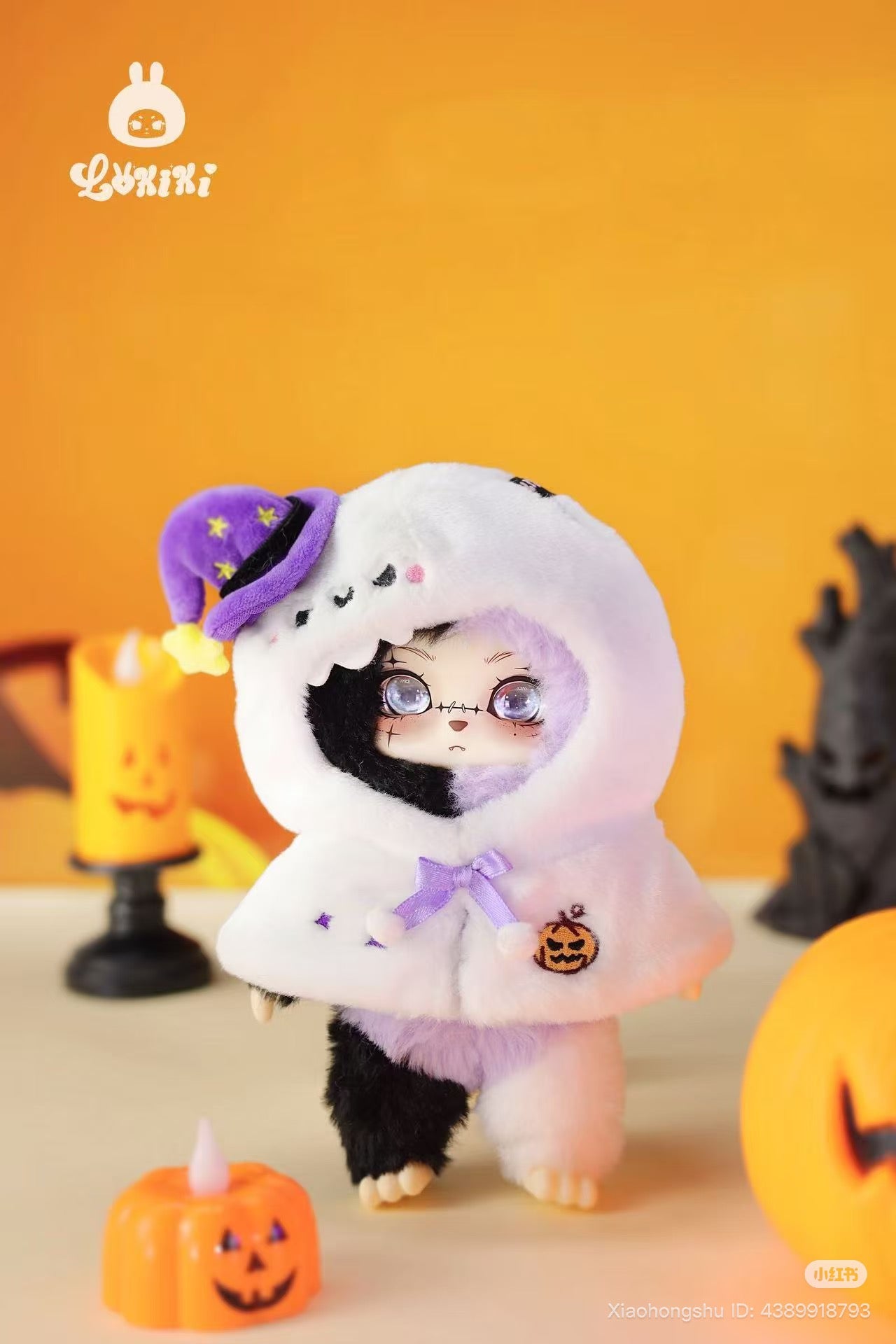 LOKKI Halloween Plush Blind Box Series doll in ghost cape with witch hat, surrounded by Halloween pumpkins; preorder from Strangecat Toys, known for art toys.