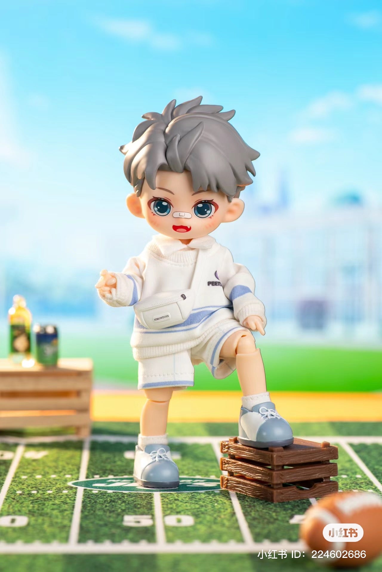 A toy boy and doll on wooden crates with a plastic crate and shoe. Close-ups of cartoon head, football, and toy.