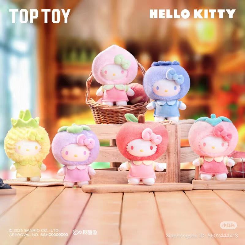Sanrio Fruit Paradise Plush Keychain Blind Box Series featuring six Hello Kitty dolls in fruit costumes, displayed on a tabletop with brand logos visible.