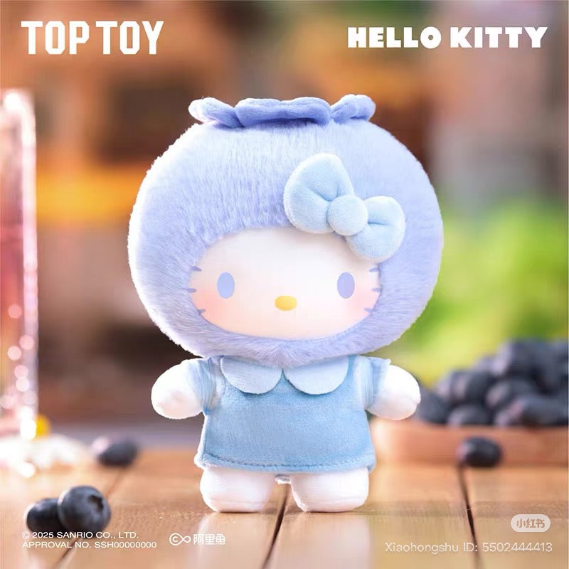 Sanrio Fruit Paradise Plush Keychain Blind Box Series: Hello Kitty in blueberry costume, featuring a fuzzy blue hood with bow and leaf, set on wooden surface.