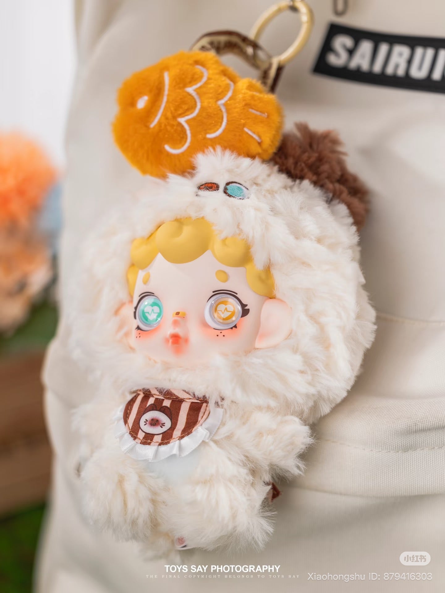 Wonderfull ruri Animal Stealth Operation Series Plush Pendant: Sheep-suited doll keychain with big eyes, striped bib, and mini fish charm. Preorder for October 2025 delivery.