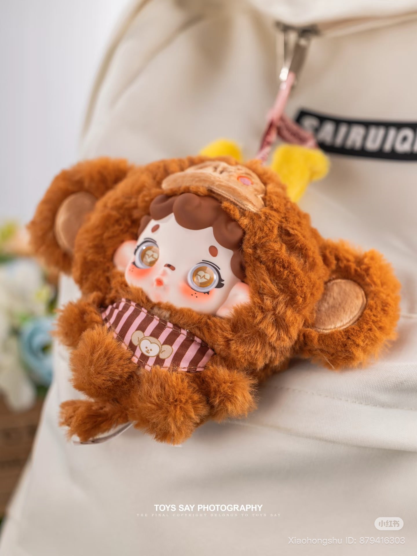 Wonderfull ruri Animal Stealth Operation Series Plush Pendant adorning a backpack zipper, featuring a doll in a monkey hood. Preorder for shipment by October 2025.