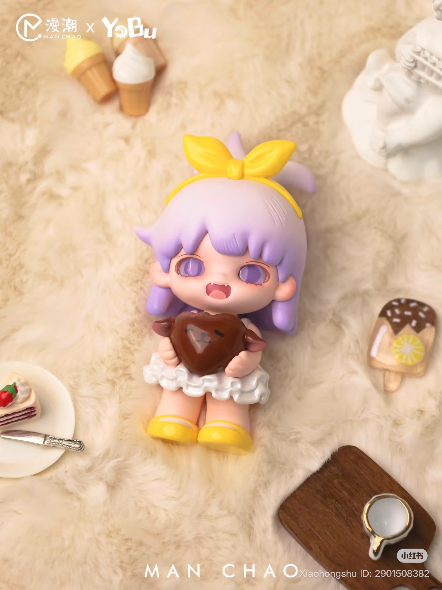 Chibi-style figure from YOBU - It's A Bit Sweet Blind Box Series, holding heart candy, surrounded by miniature desserts, showcasing Strangecat Toys' playful art toy collection.