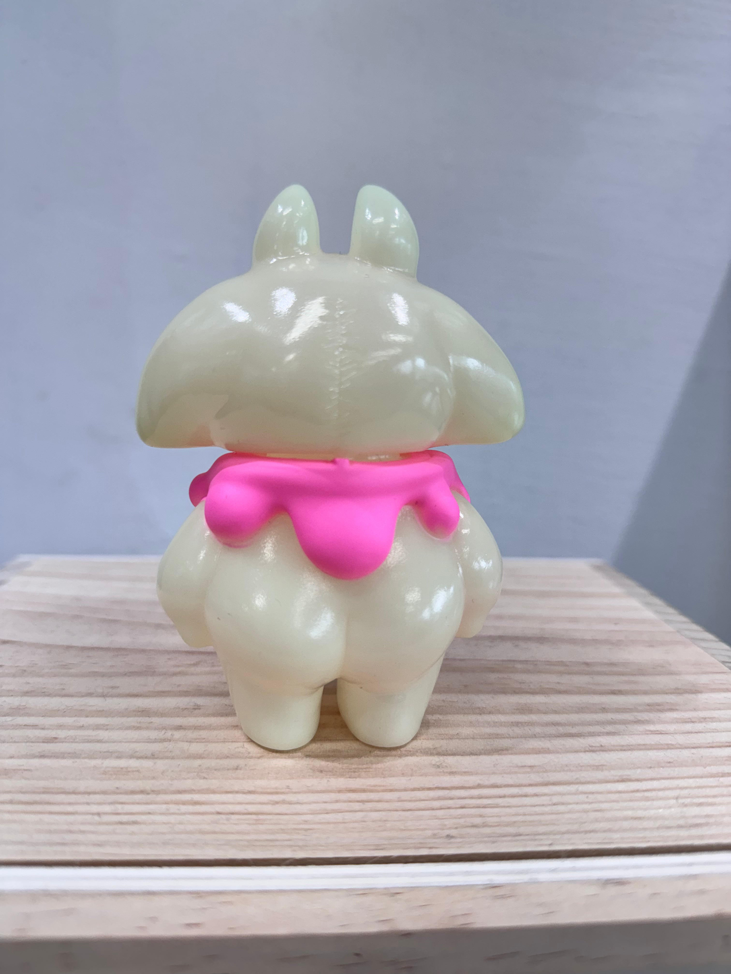 Manta Baby by Yu-zu Tunofue, a 12cm cream-colored vinyl figure with bunny ears and a pink drippy collar, stands on a wooden block.