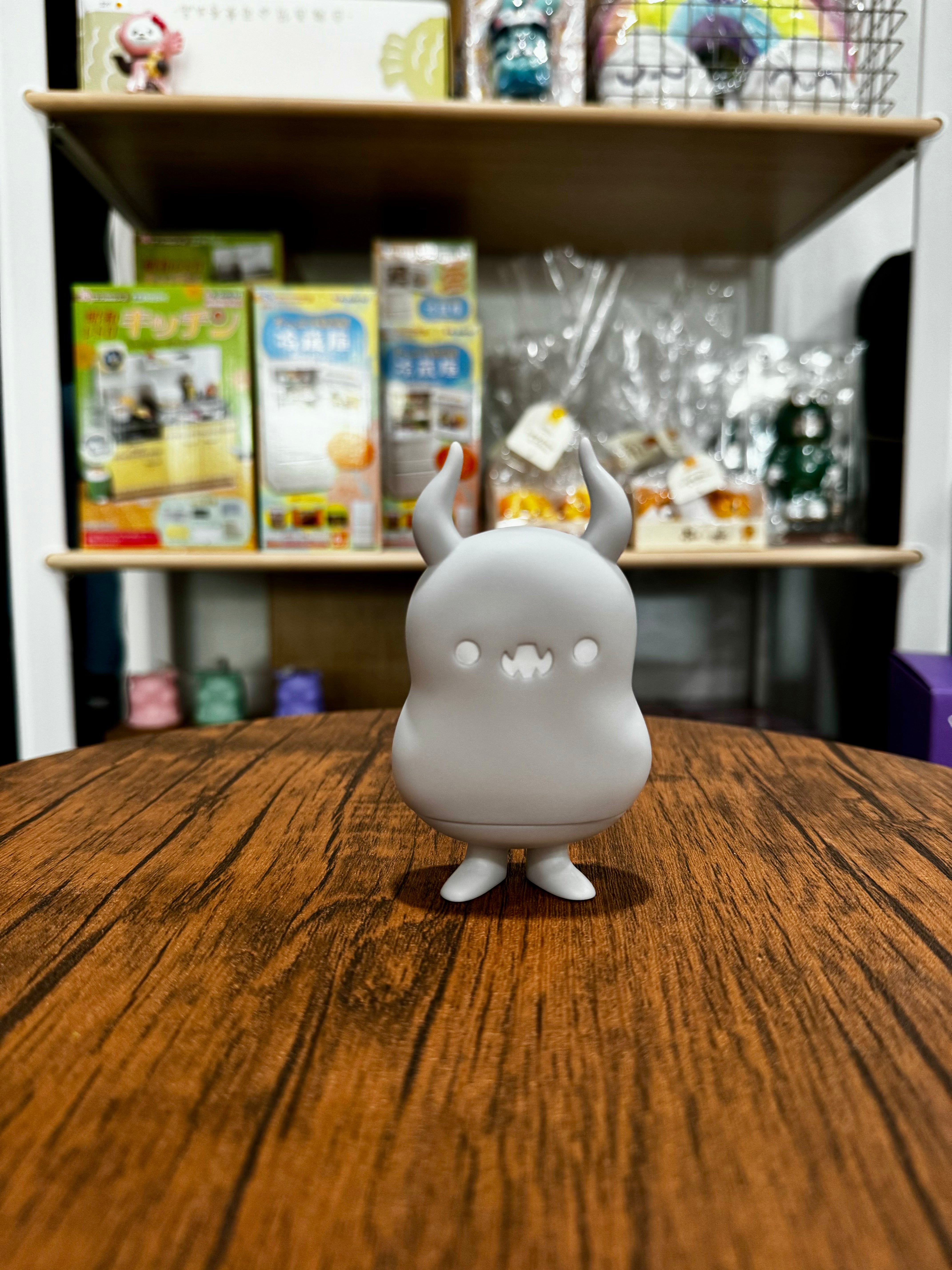 Babababa - Gray Days by Chishima Konosuke, a small white cartoon-style sofubi toy, displayed on a table.