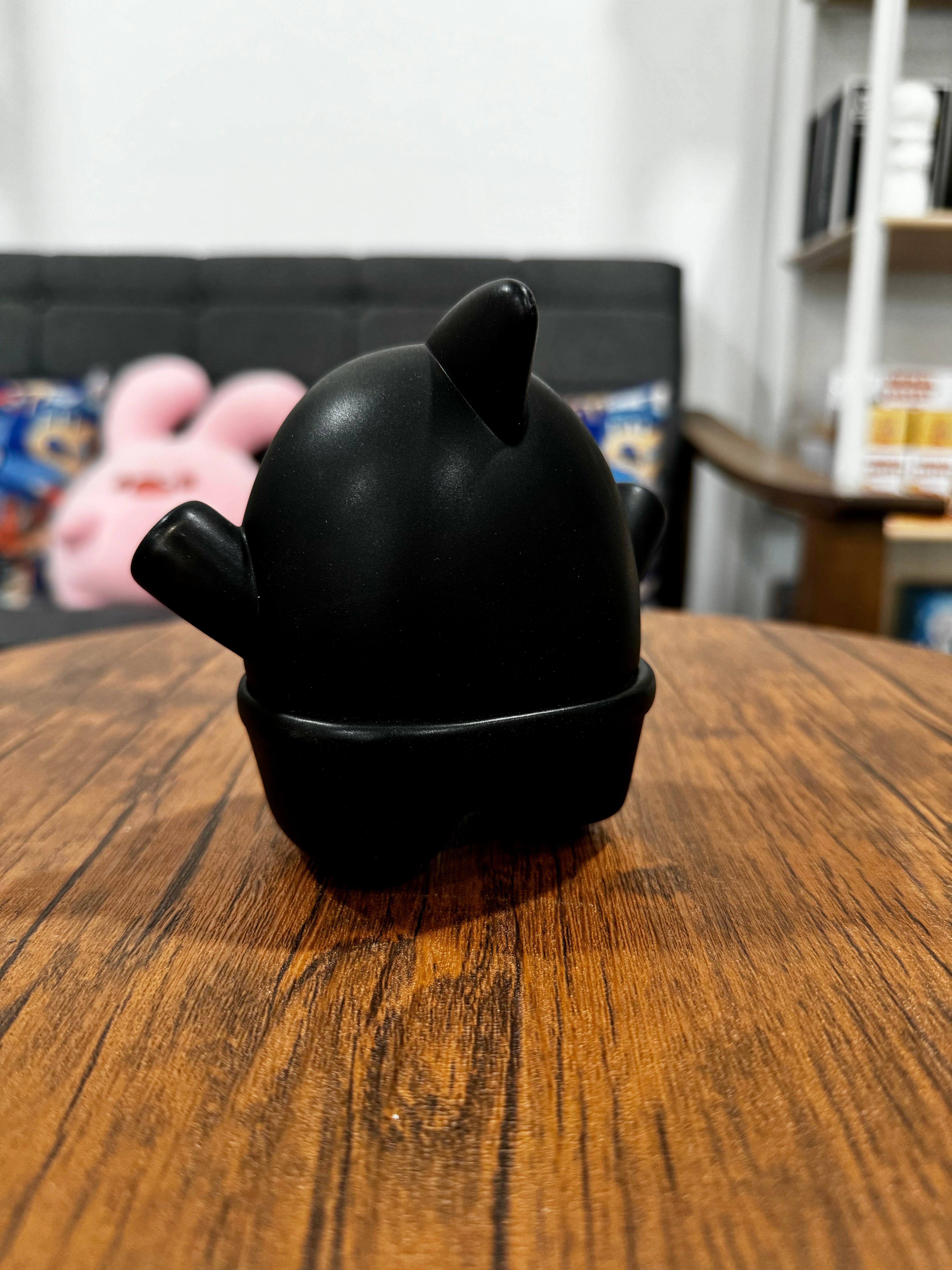 A black toy shark figurine, 11.5cm, titled SHARK Light in the Dark by CO2, showcased on a table. Reflects Strangecat Toys' blind box and art toy store essence.