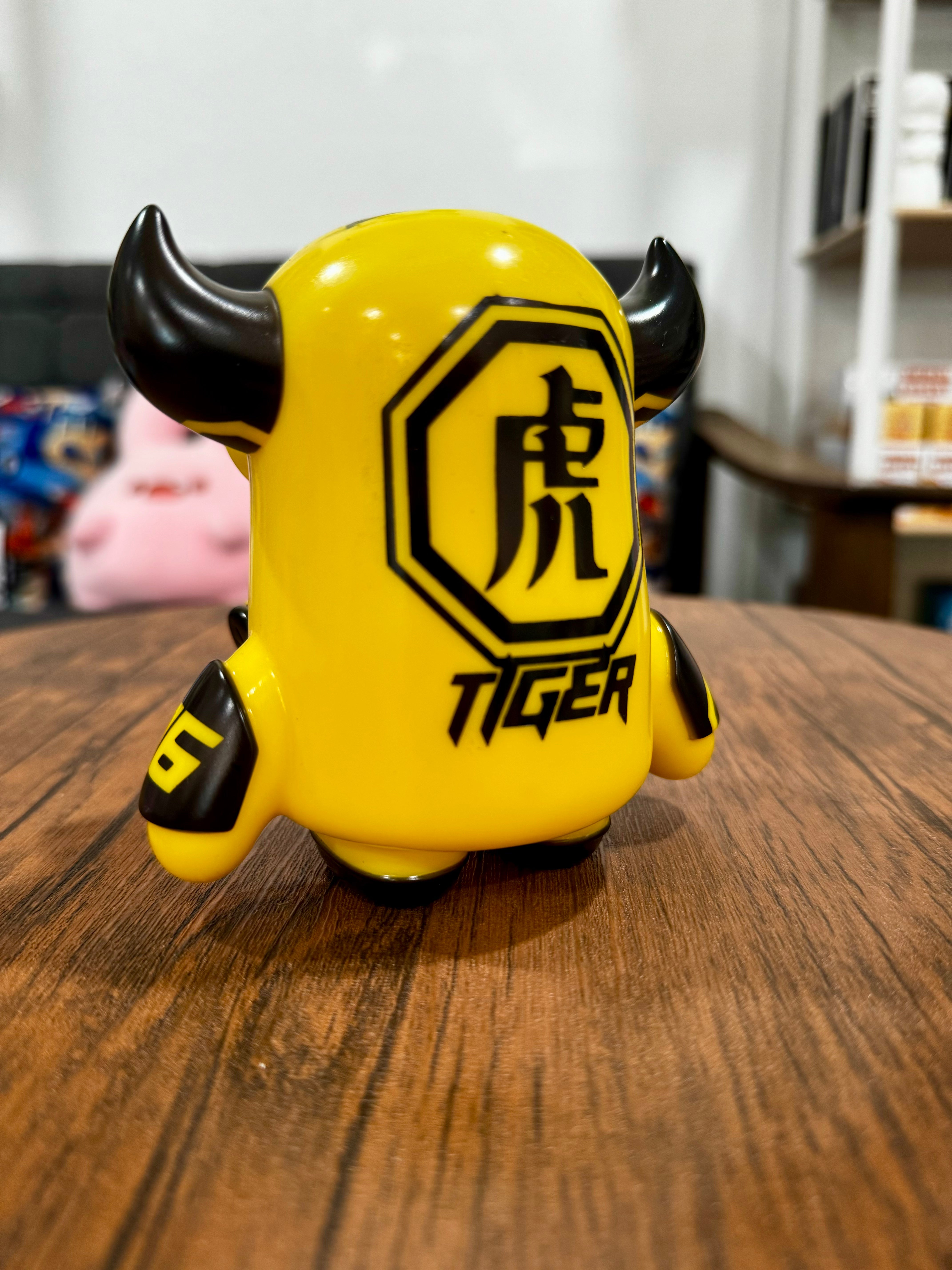 A Sofubi toy, 11.5cm, titled MASK BULL Tiger Squad by CO2, featuring a yellow and black animal figure on a table.