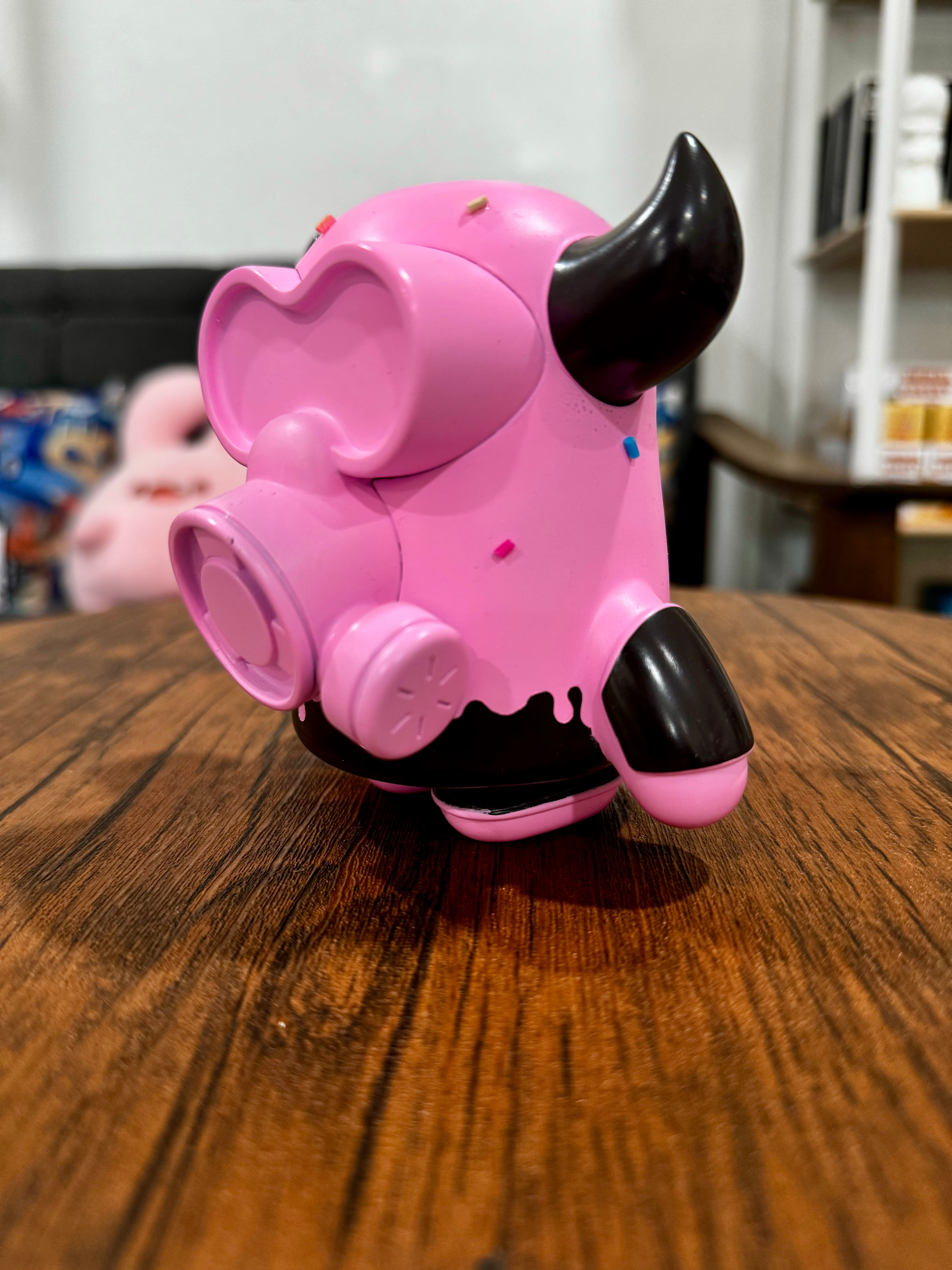 A pink Sofubi toy resembling a bull with horns and a gas mask, titled MASK BULL StrawBerry Spray Chocolate by CO2. Characteristic of Strangecat Toys' blind box and art toy store.