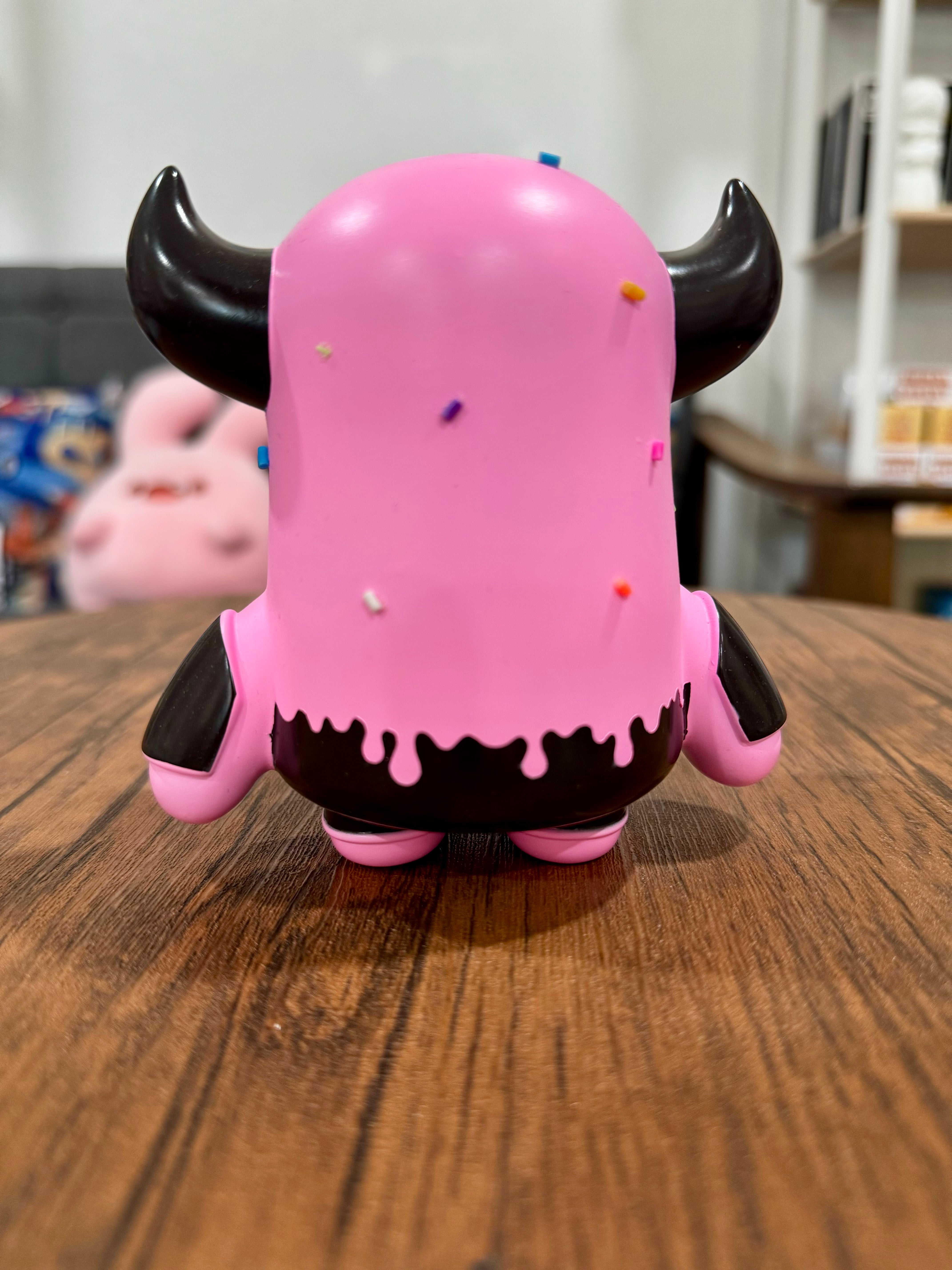 A blind box Sofubi toy, MASK BULL StrawBerry Spray Chocolate by CO2, featuring a pink and black animal figure. Ideal for collectors.