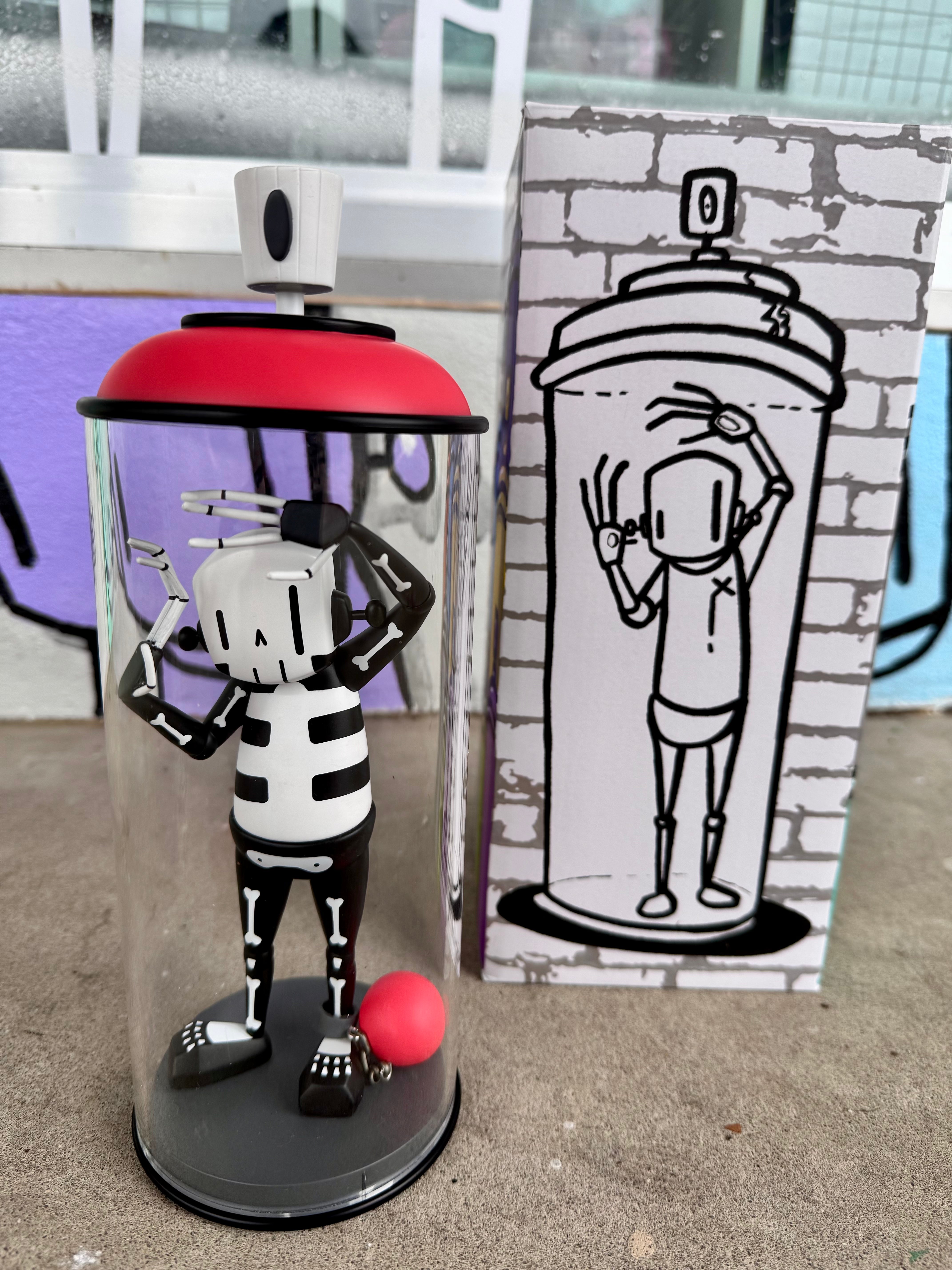 Contents Under Pressure Vinyl Figure - Bones Edition by Chris RWK: a stylized skeleton in a clear acrylic can with red accents, limited edition collectible.