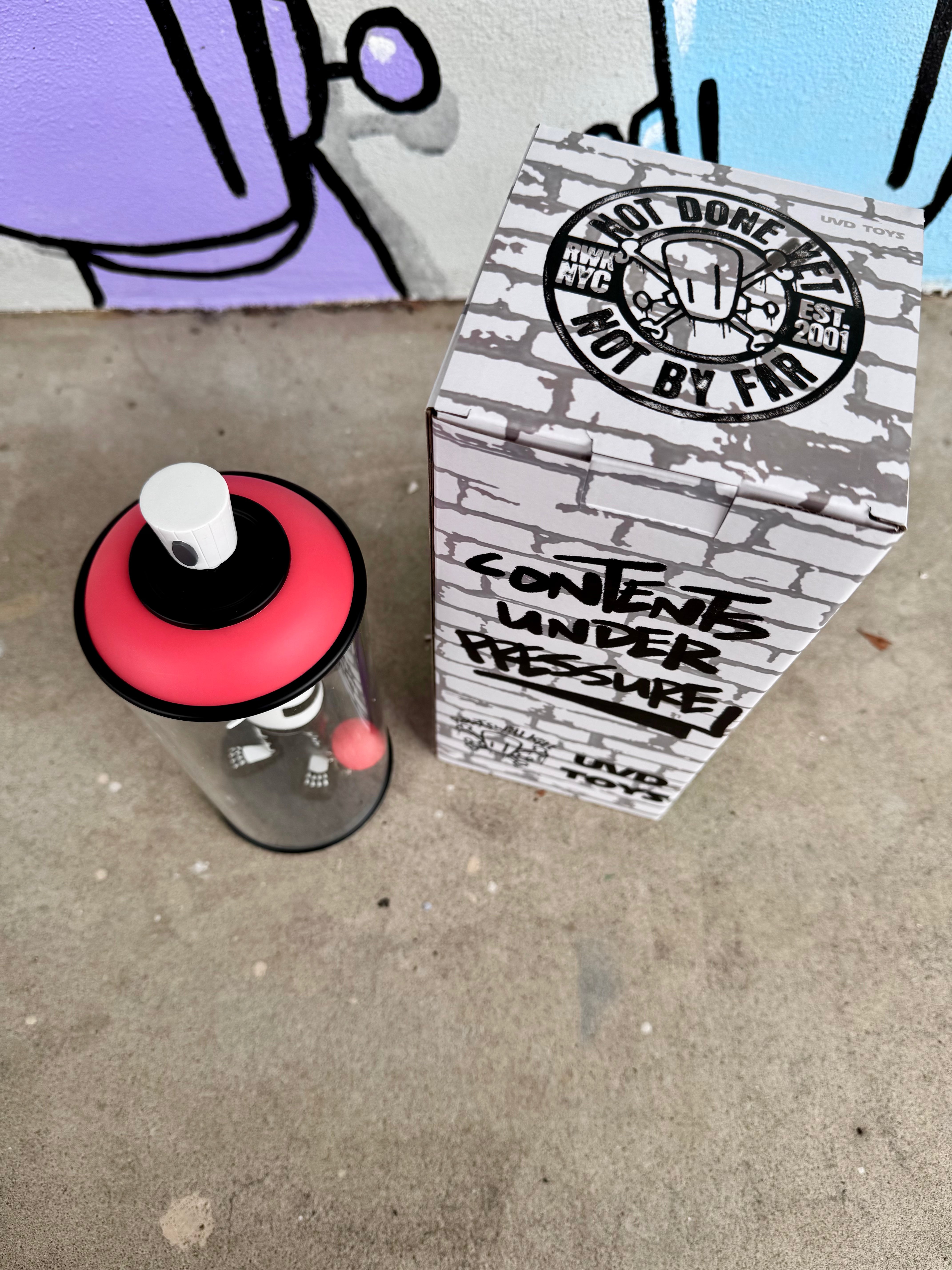 Contents Under Pressure Vinyl Figure - Bones Edition by Chris RWK, featuring a skeleton character in a clear canister beside a brick-patterned box, limited to 100 pieces.