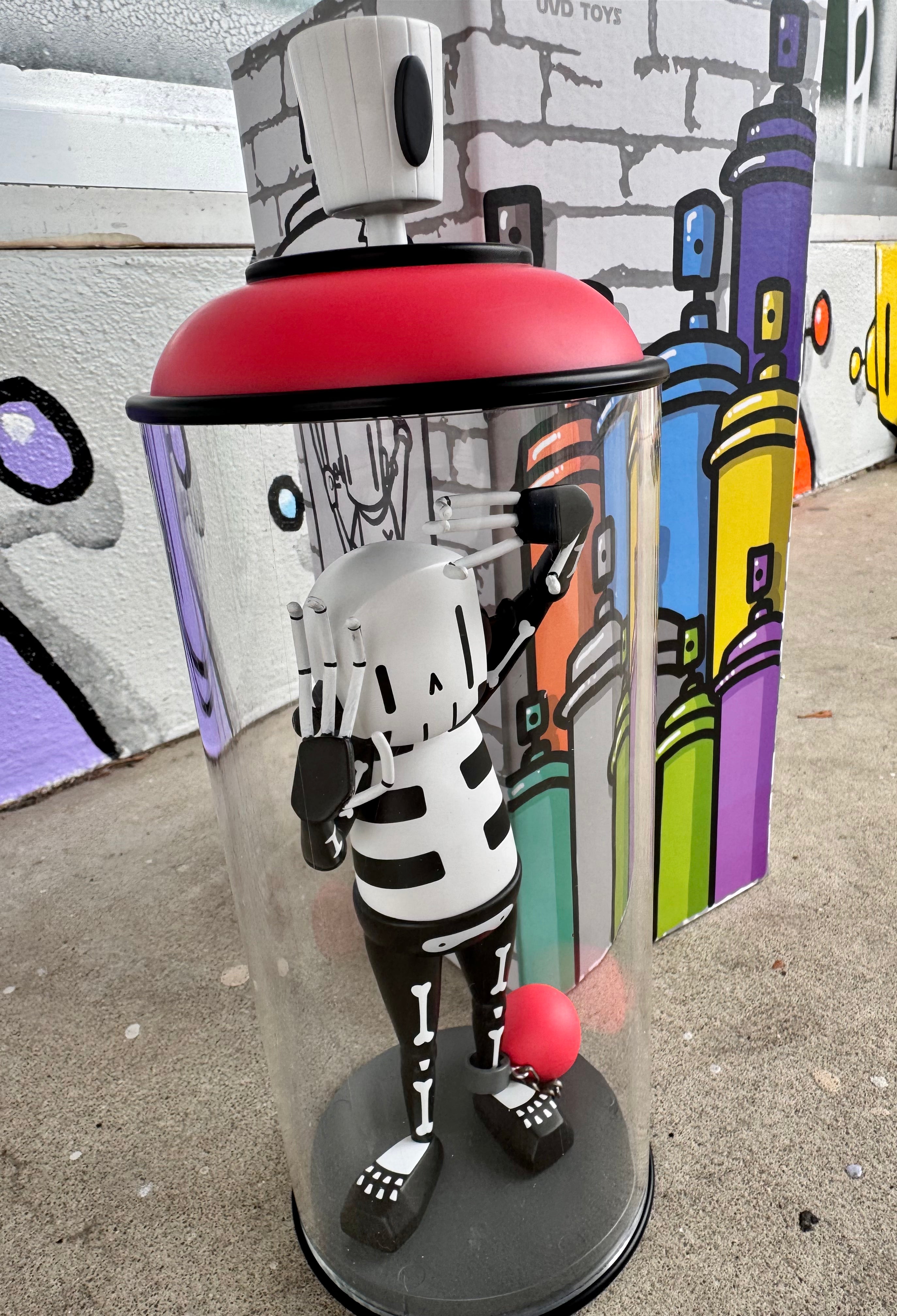 Contents Under Pressure Vinyl Figure - Bones Edition by Chris RWK displayed in an acrylic case with red accents, featuring a stylized skeleton art toy.