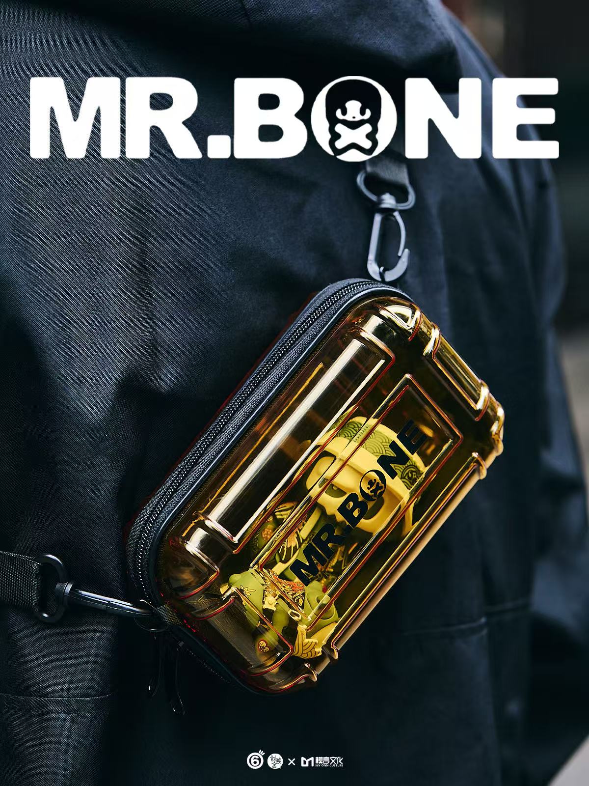 Mr Bone Yakuza Limited Set 100% - Preorder: Transparent amber-tinted pouch with MR. BONE branding, carabiner attached, containing a small skeleton-style figurine inside.