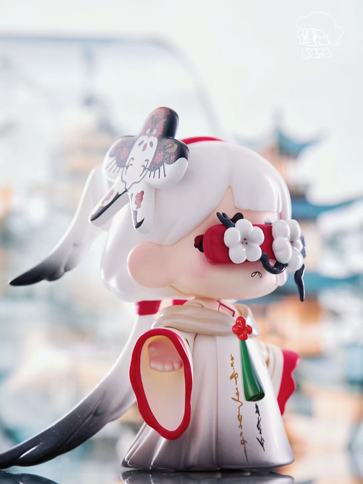 KASA 2.0 - Mystic Tales Blind Box Series figure in kimono with crane ornament, plum-blossom goggles, and tassel, displayed on reflective surface.
