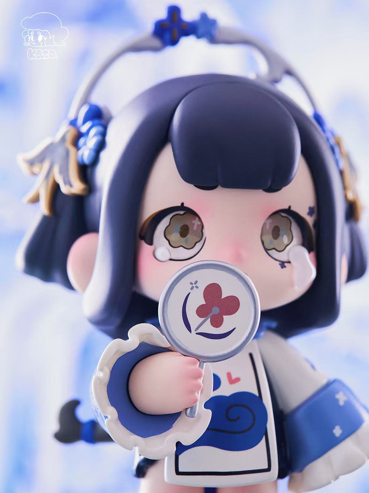 KASA 2.0 - Mystic Tales Blind Box Series chibi-figure with dark hair, oversized eyes, cloud motifs, holding a fan with a pink flower emblem.