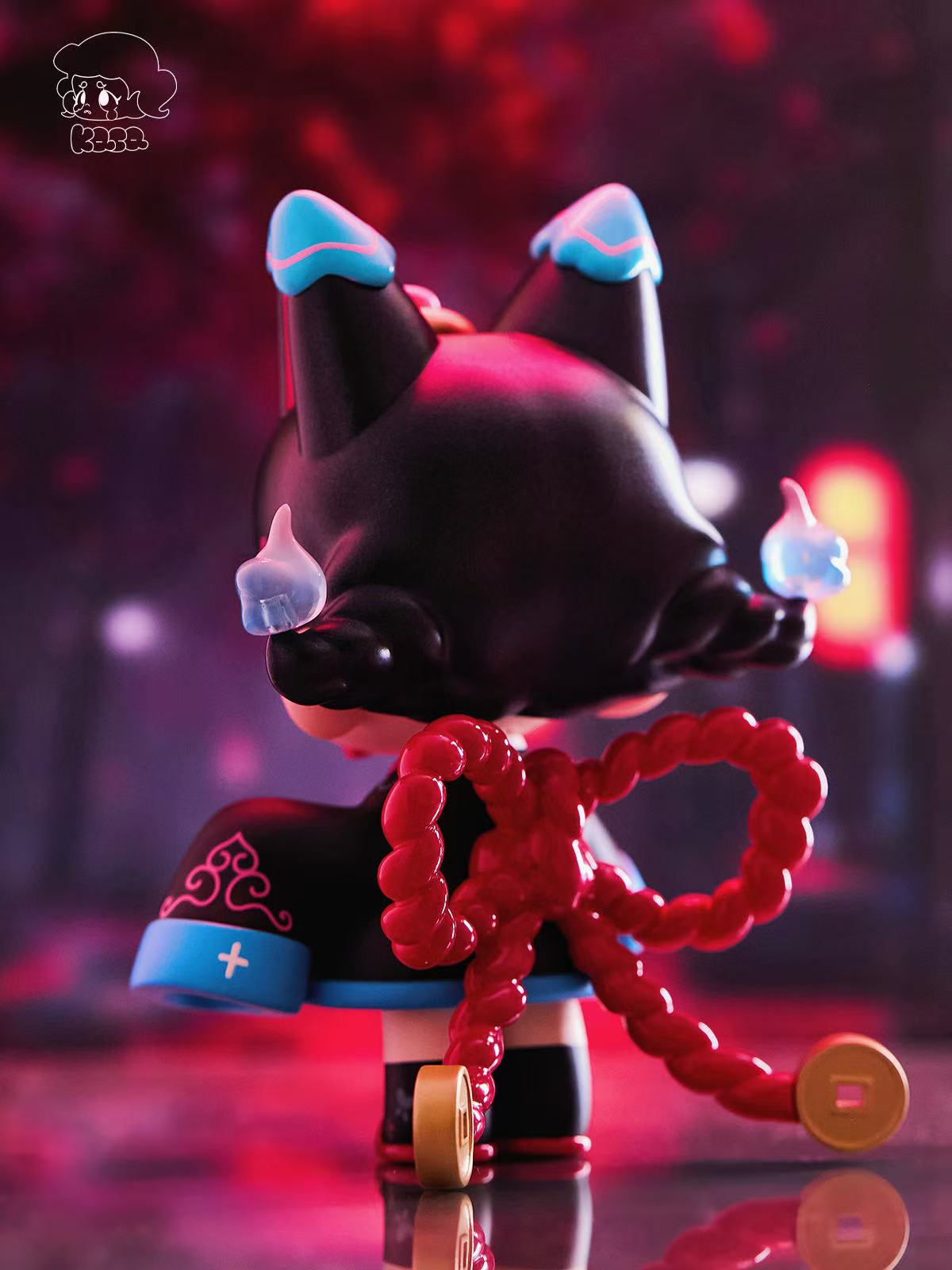 KASA 2.0 - Mystic Tales Blind Box Series figurine with dual-bun hair, icy flames, red braided bow with coins, in a black robe with blue trim.