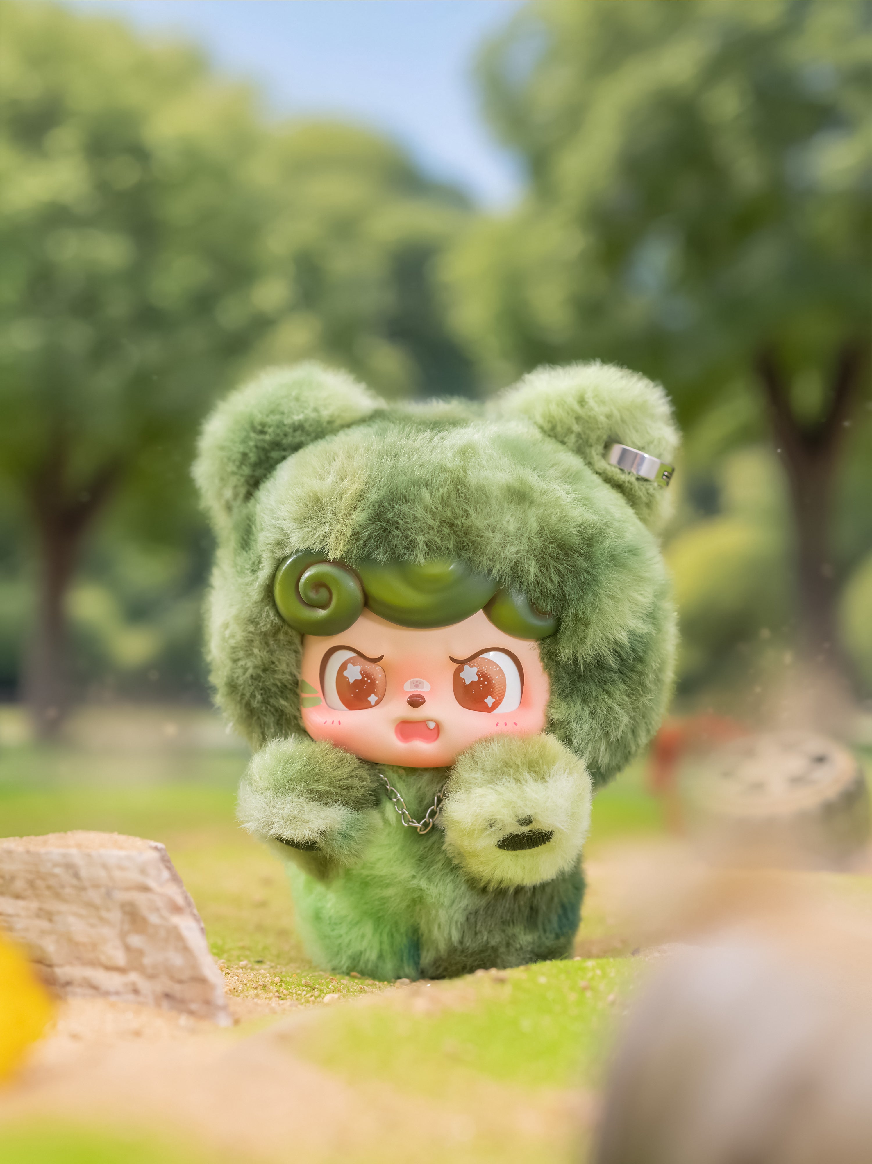 Designer toy in a fluffy bear suit with sparkly eyes, part of the Q. Kid Outdoor Activities Series PVC Plush Blind Box, set outdoors on grass.