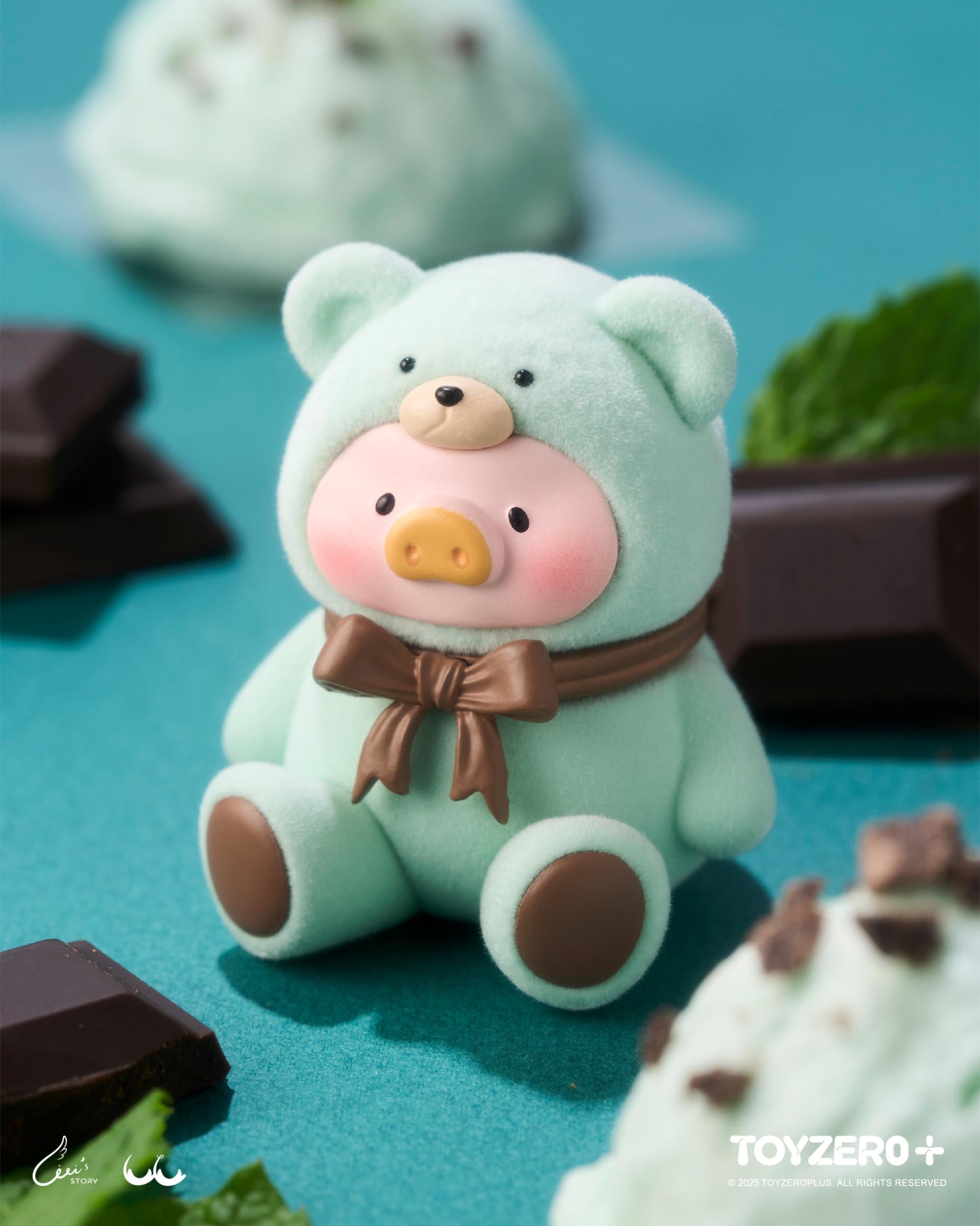 LuLu the Piggy - Teddy MINI Limited Edition (Summer Chill) in a bear costume, posed with mint leaves and chocolate on a teal surface, part of TOYZERO+ lineup.