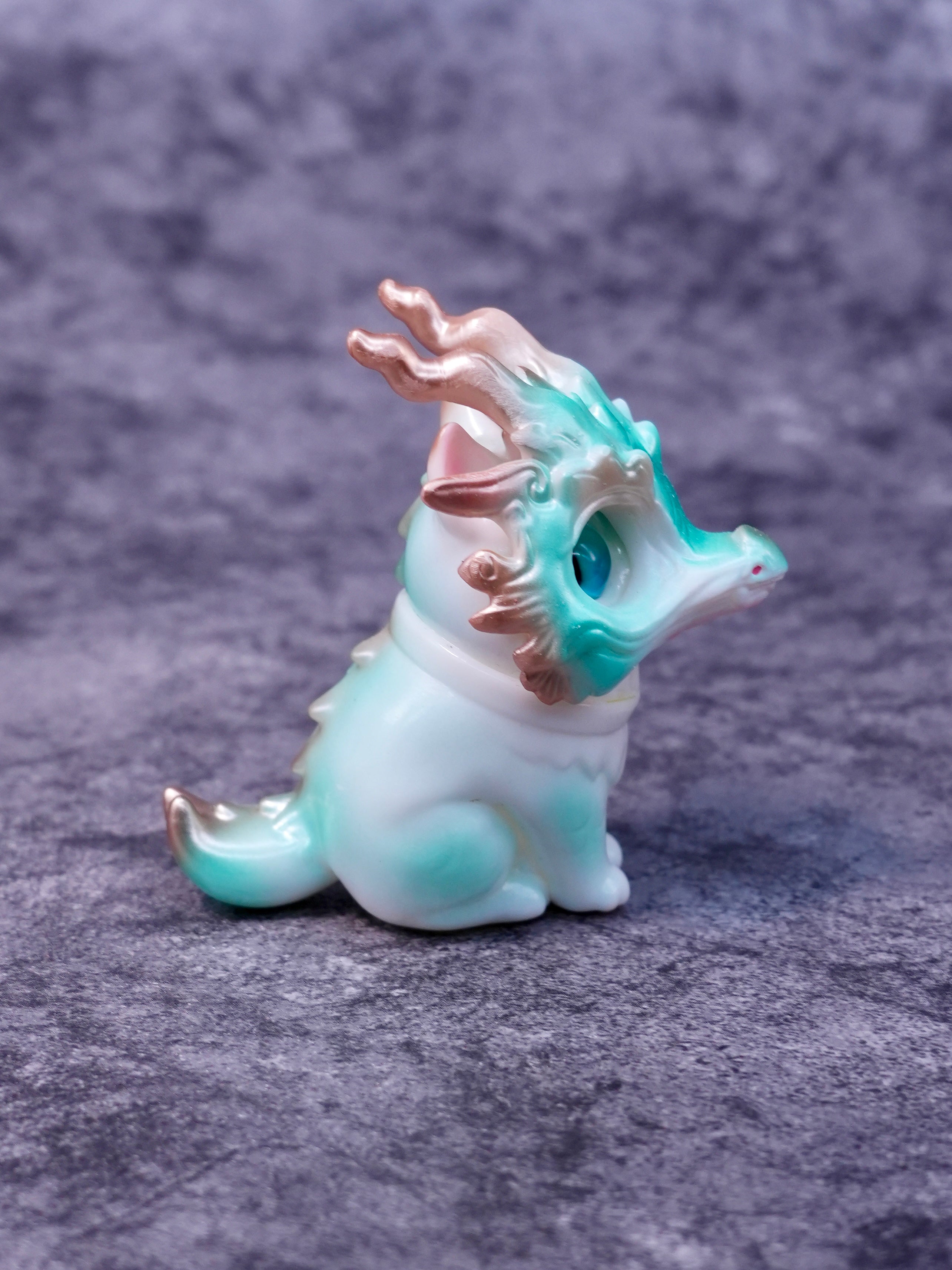 Little Azure Loong by HOTRU: A small, chubby figurine with a dragon mask, featuring a rotatable head and magnetically attached mask, embodying playful artistry.