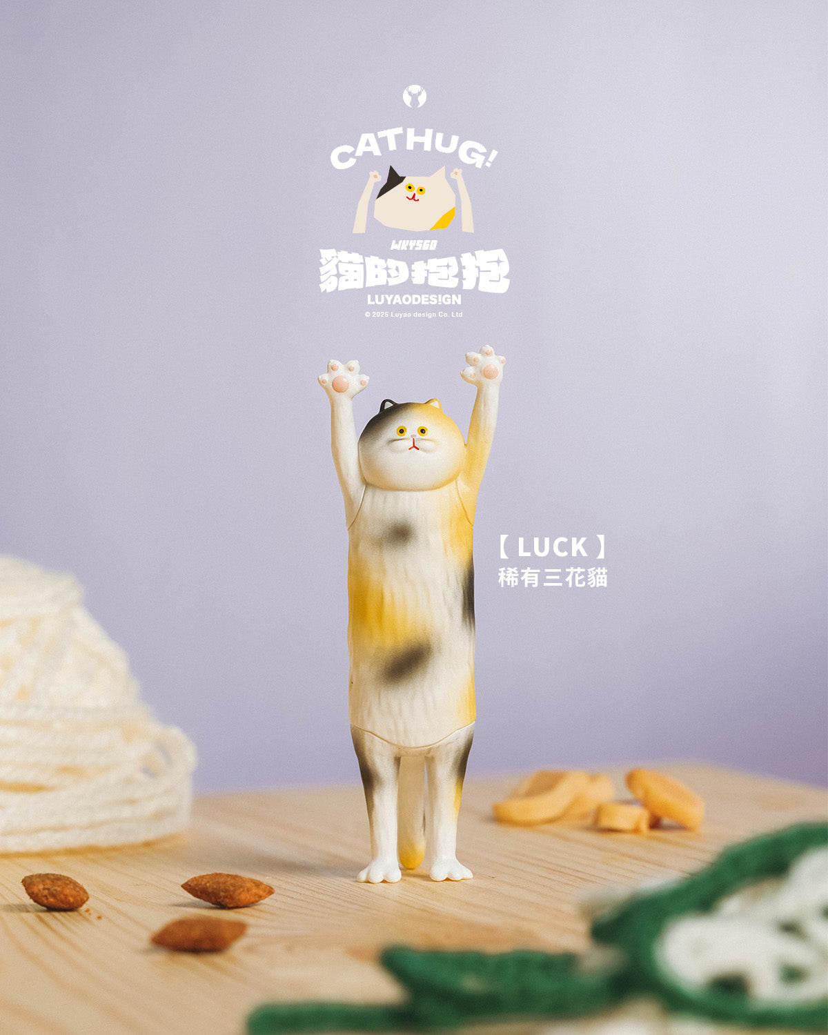 Cat Hug Blind Box Series: Designer calico cat figure with raised paws on a wooden surface, surrounded by nuts, yarn, and knit piece. Preorder for October 2025.