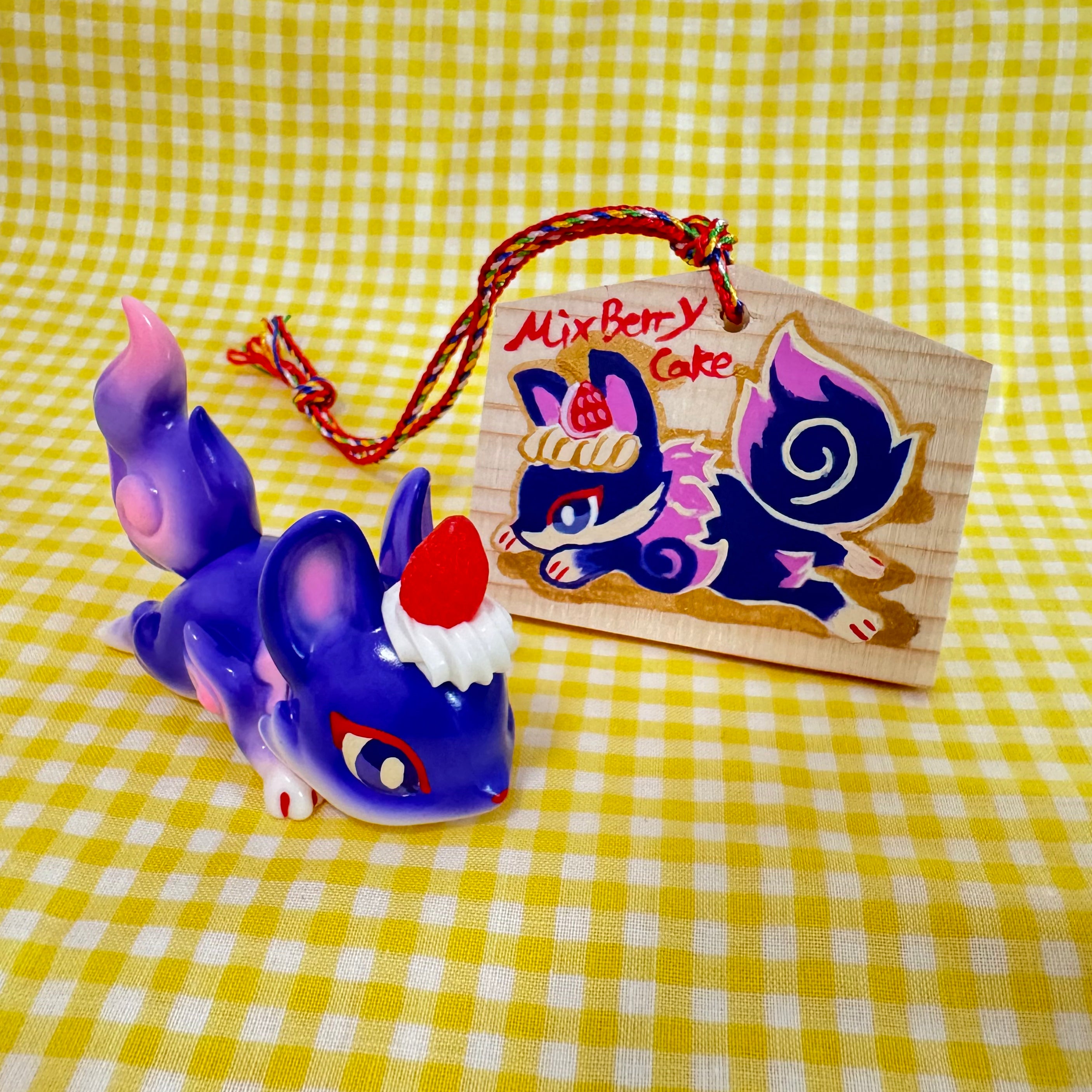 Little Sleeping Fox - Mixed Berry Cheesecake by Genkosha, a 6cm soft vinyl toy, displayed on a yellow and white checkered surface.