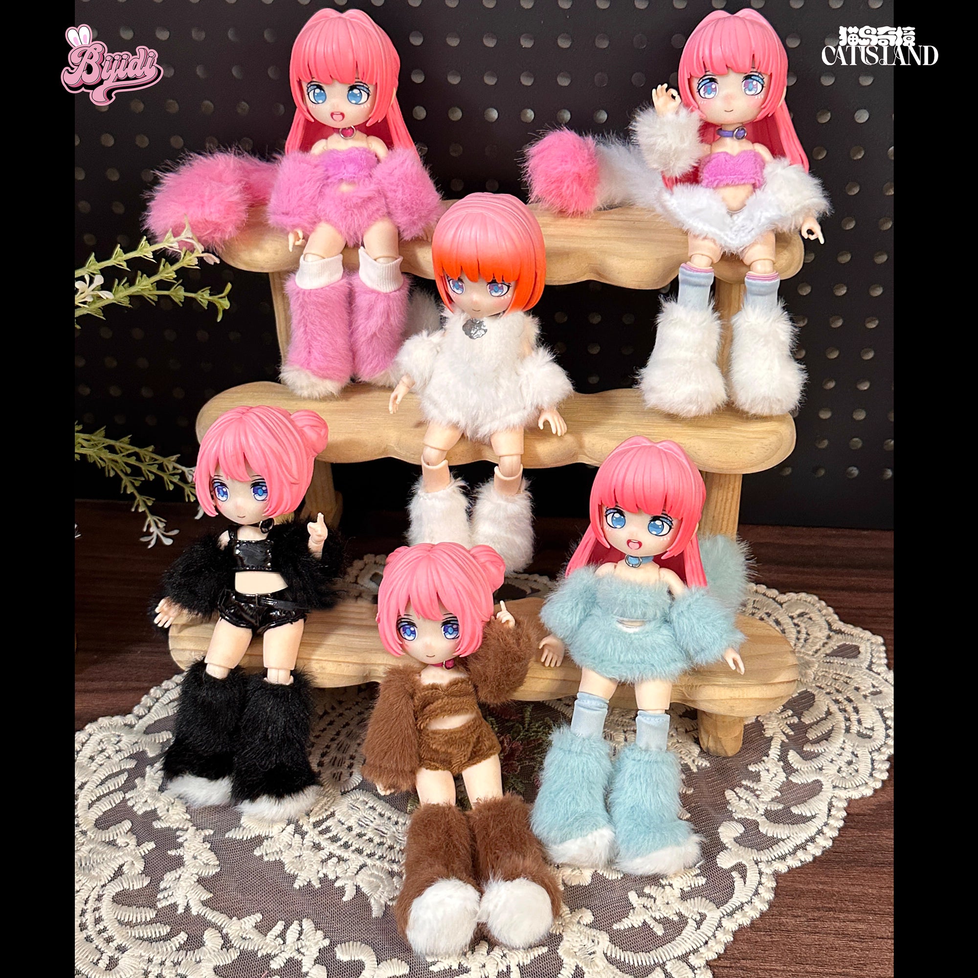 Three-tier wooden stand displaying pink-haired, blue-eyed anime dolls from the Cat Island-Black Cat Or Candy Cat Series Articulated Figure Blind Box, set on a lace doily.