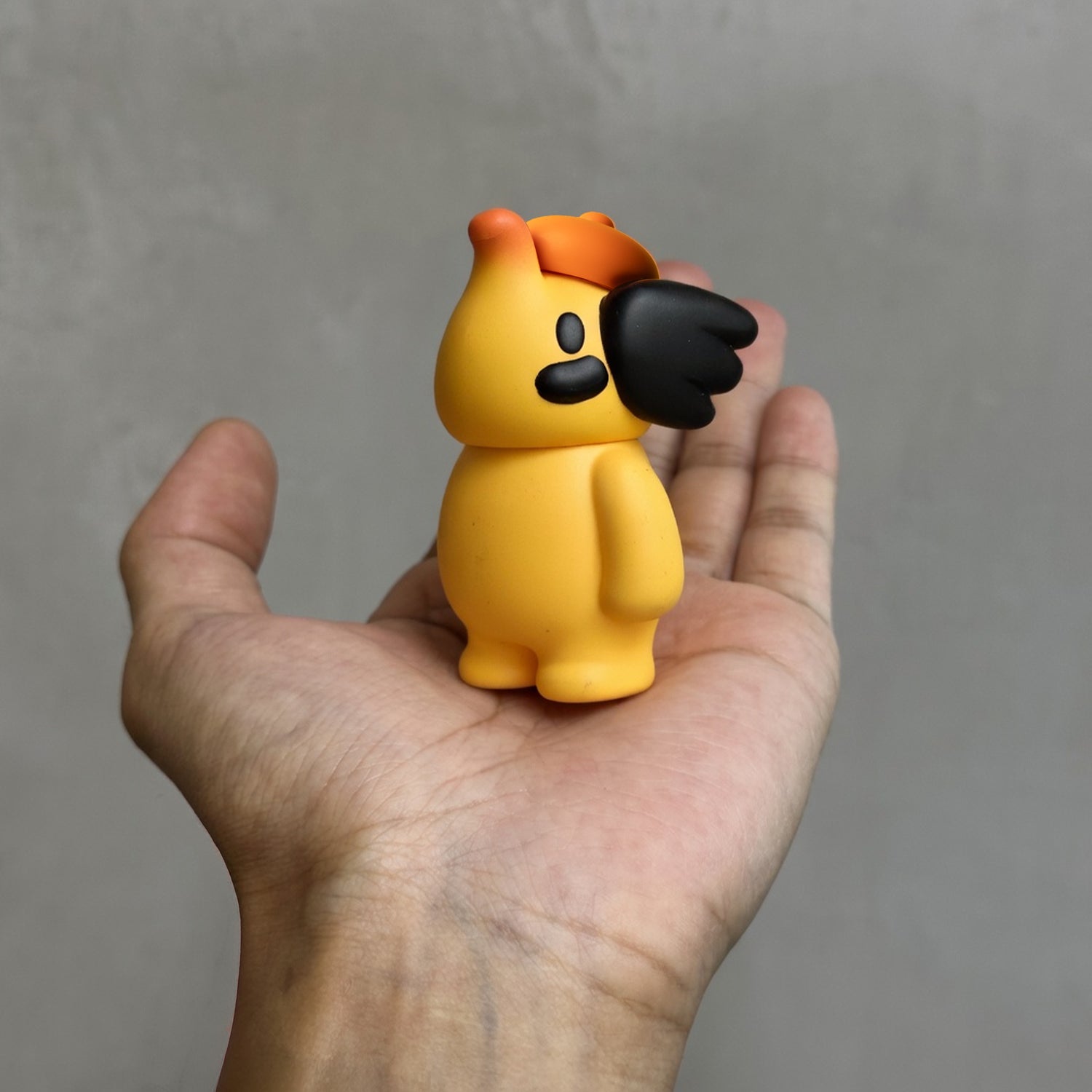 ELFIE HERE I AM! 100% OHIGEnoPON EDITION vinyl figure, bright yellow with orange cap, black accents, held in hand, perfect collectible from Strangecat Toys.