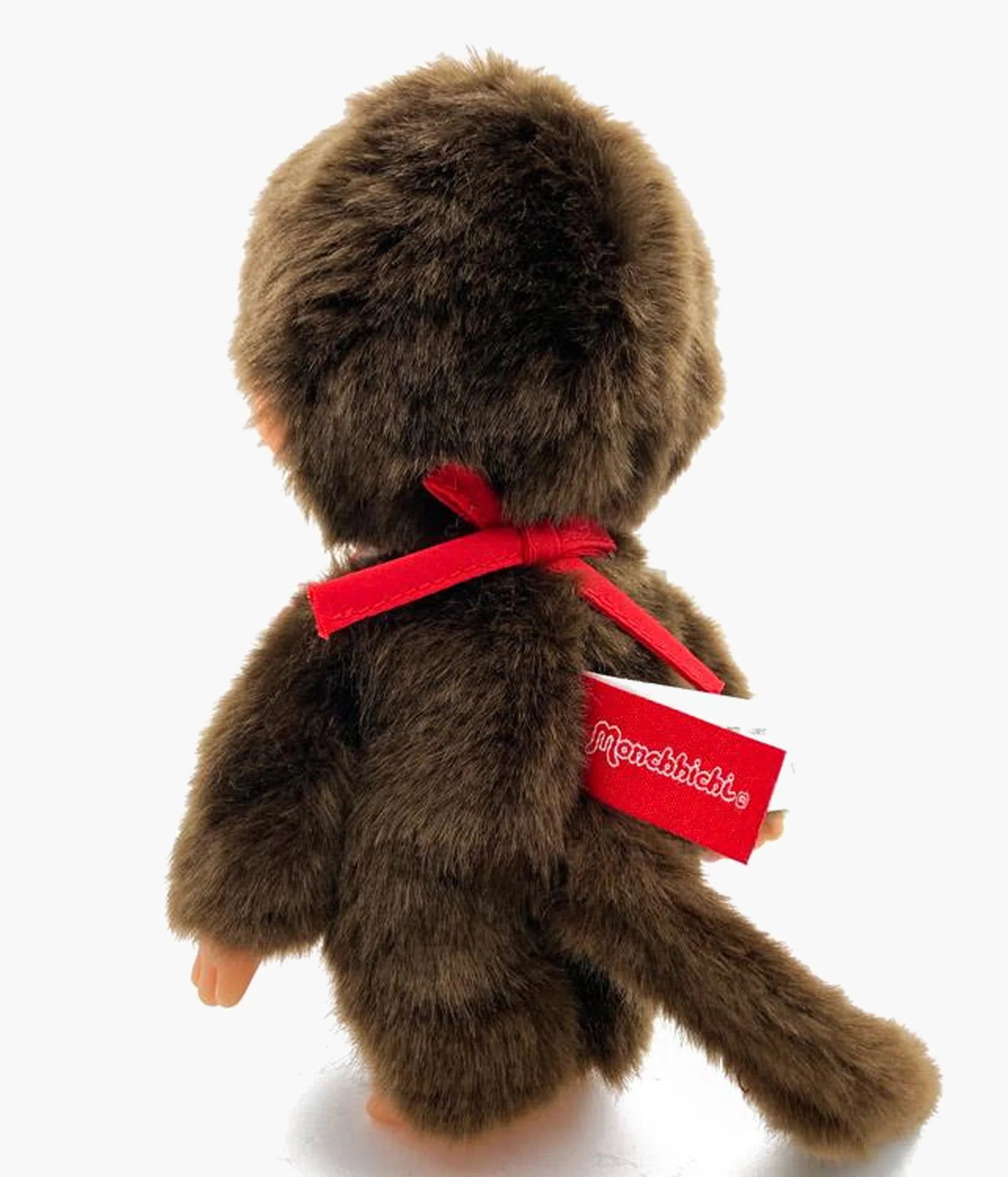 Back view of Monchhichi - Premium Standard Boy Small Plush (Japan Edition), showcasing its red ribbon and tail. Soft body with thumb-sucking feature.