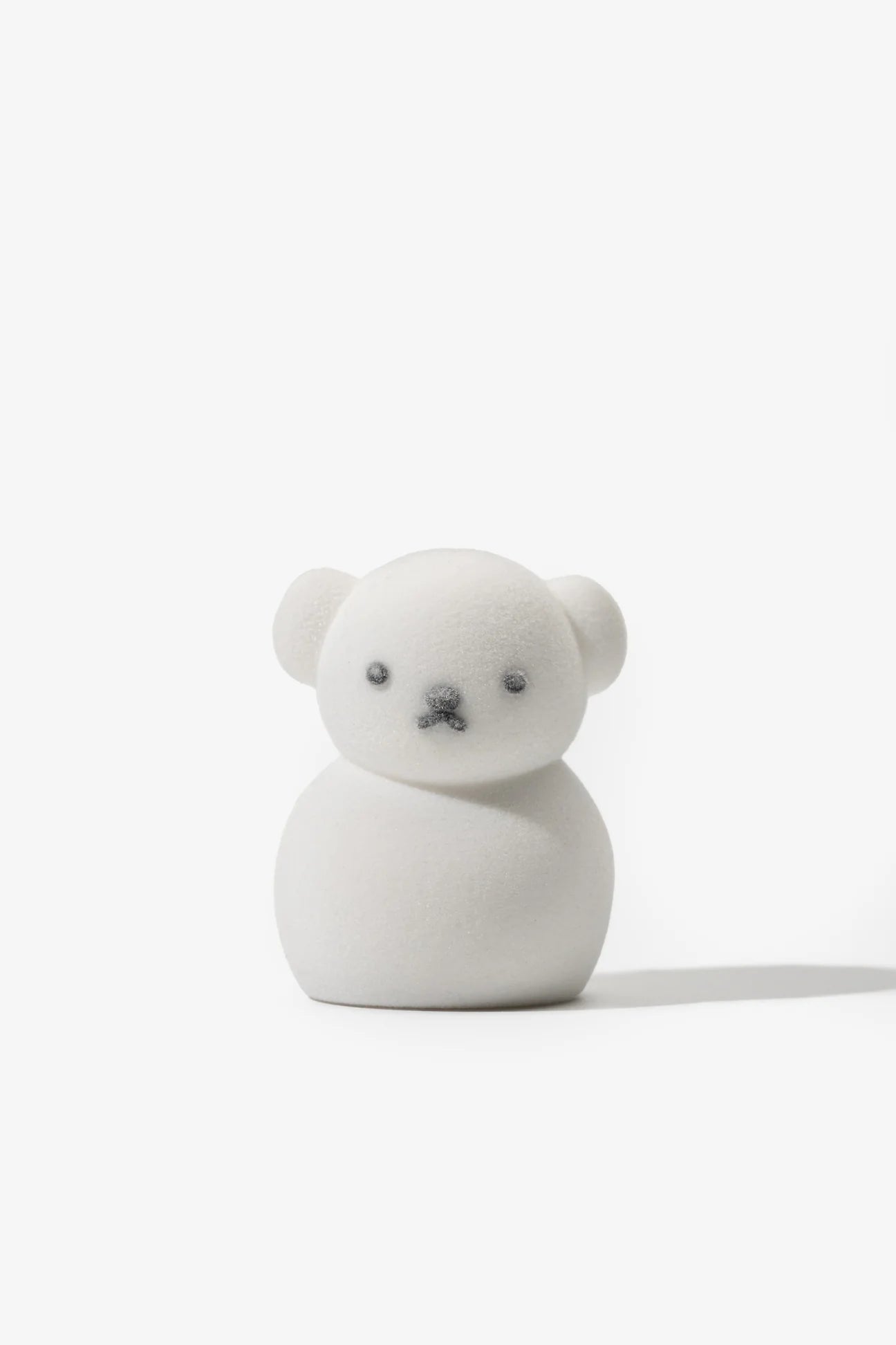 Miffy in the Snow Blind Box Figure: A white, bear-shaped collectible with smooth, velvety finish, featuring simple dot eyes and nose, measuring approximately 1.25 x 1 x 2.25 inches.