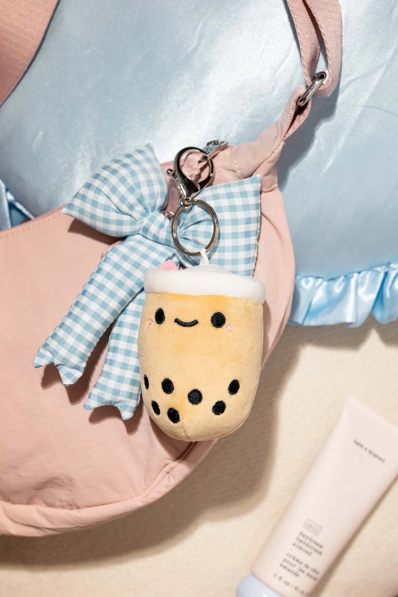 Pearl Boba Tea Bag Charm with a smiling plush design and gingham bow keychain, featuring a Smoko heart charm and embroidered tapioca details.