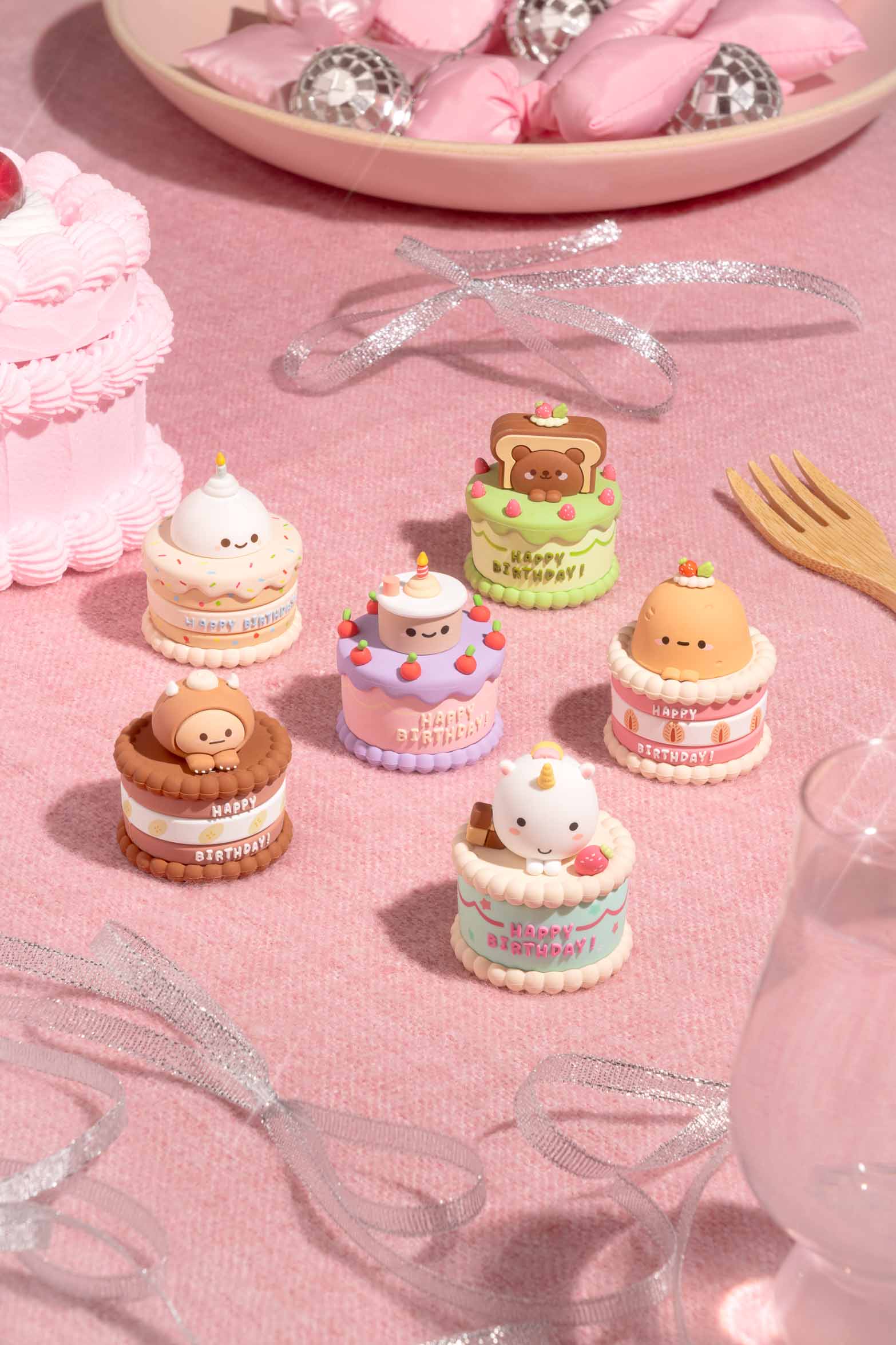 Six whimsical Smoko Friends Birthday Cake Blind Box Figures displayed on a pastel tabletop, each topped with unique kawaii-style characters celebrating birthdays in playful, collectible form.