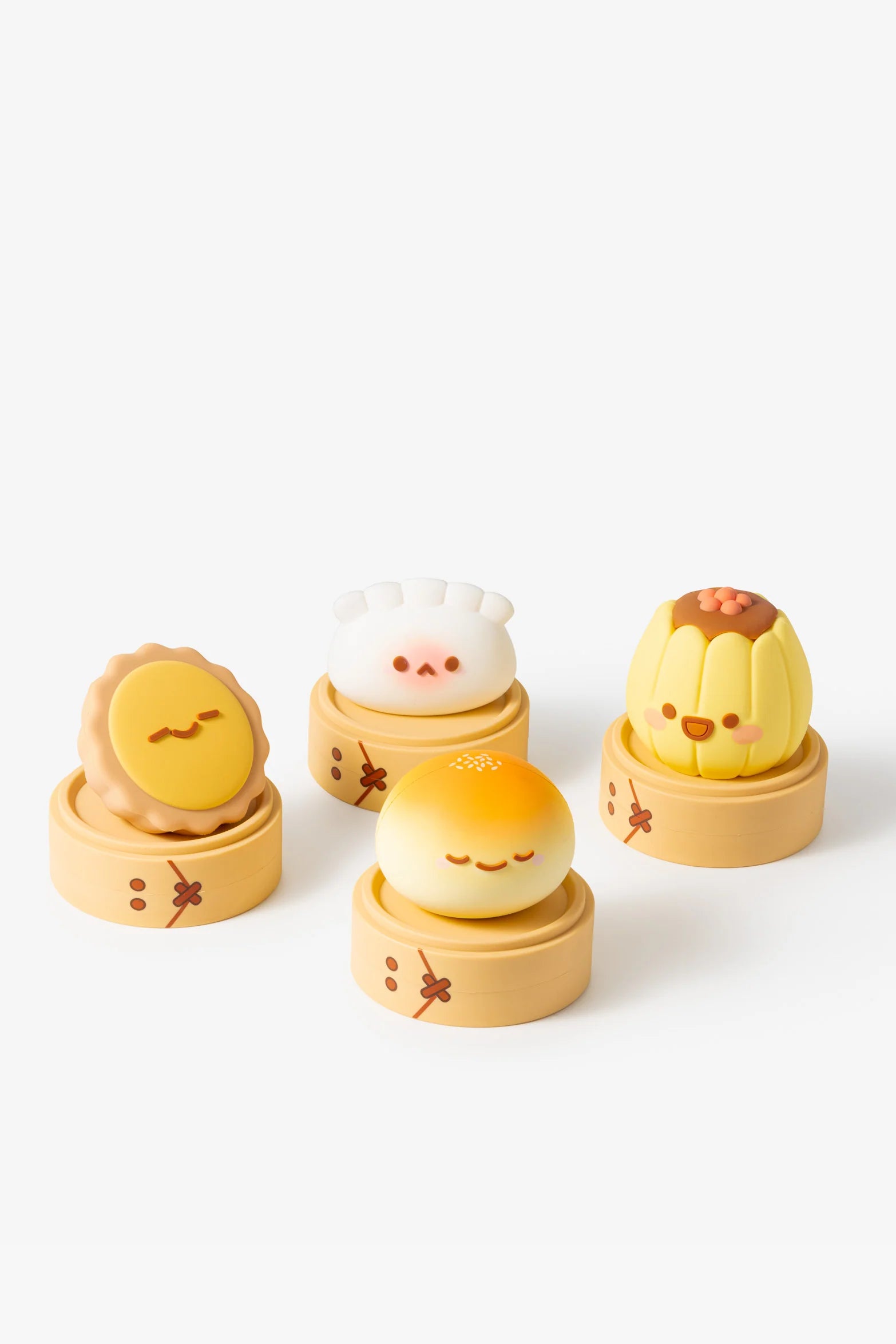 Smoko Dim Sum Friends Blind Box Figures: four novelty dim sum-themed containers with cartoon faces, each in bamboo bases, showcasing mooncake, bao, shumai, and sesame bun designs.