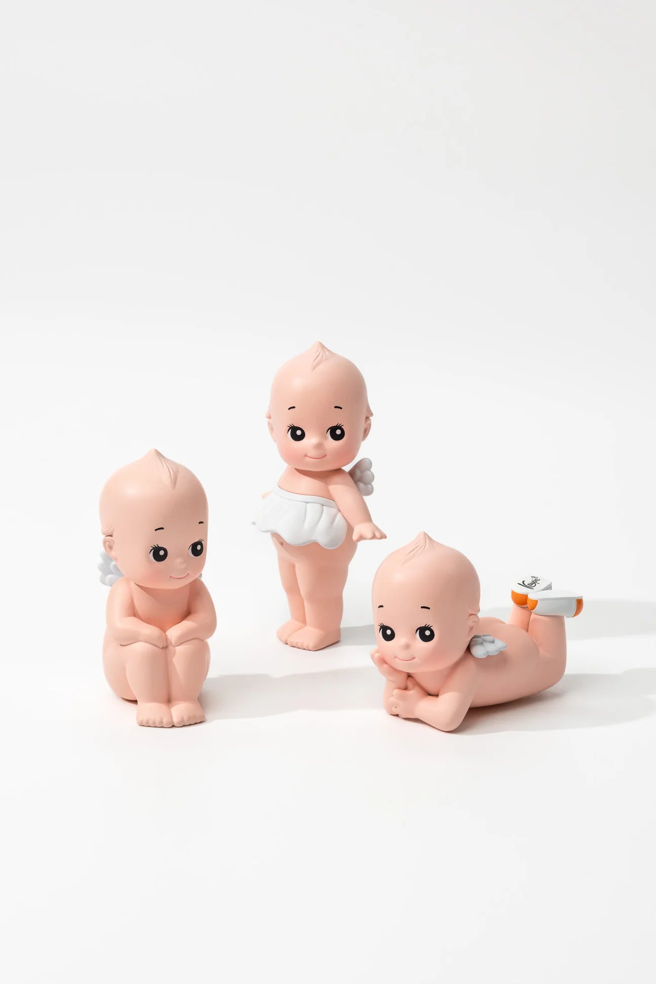 Smoko Kewpie®️ Blind Box Figure features three chubby, angelic baby figurines with wings, each uniquely posed, offering a surprise collectible experience.