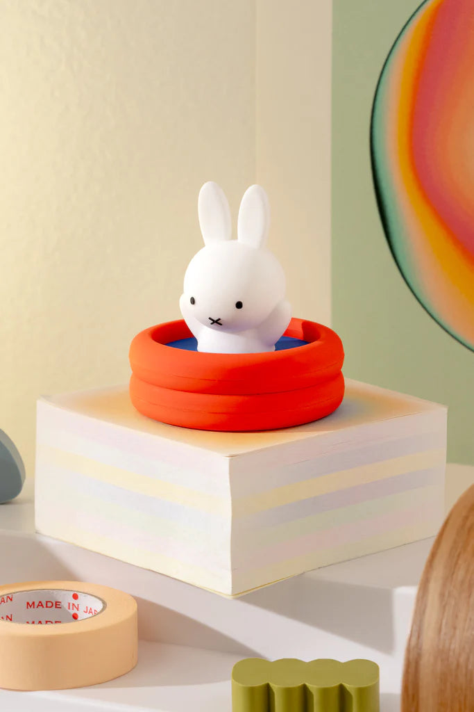 Miffy figurine in orange kiddie pool atop pastel block; part of Miffy Doing Things Blind Box collection, featuring surprise collectible figures.