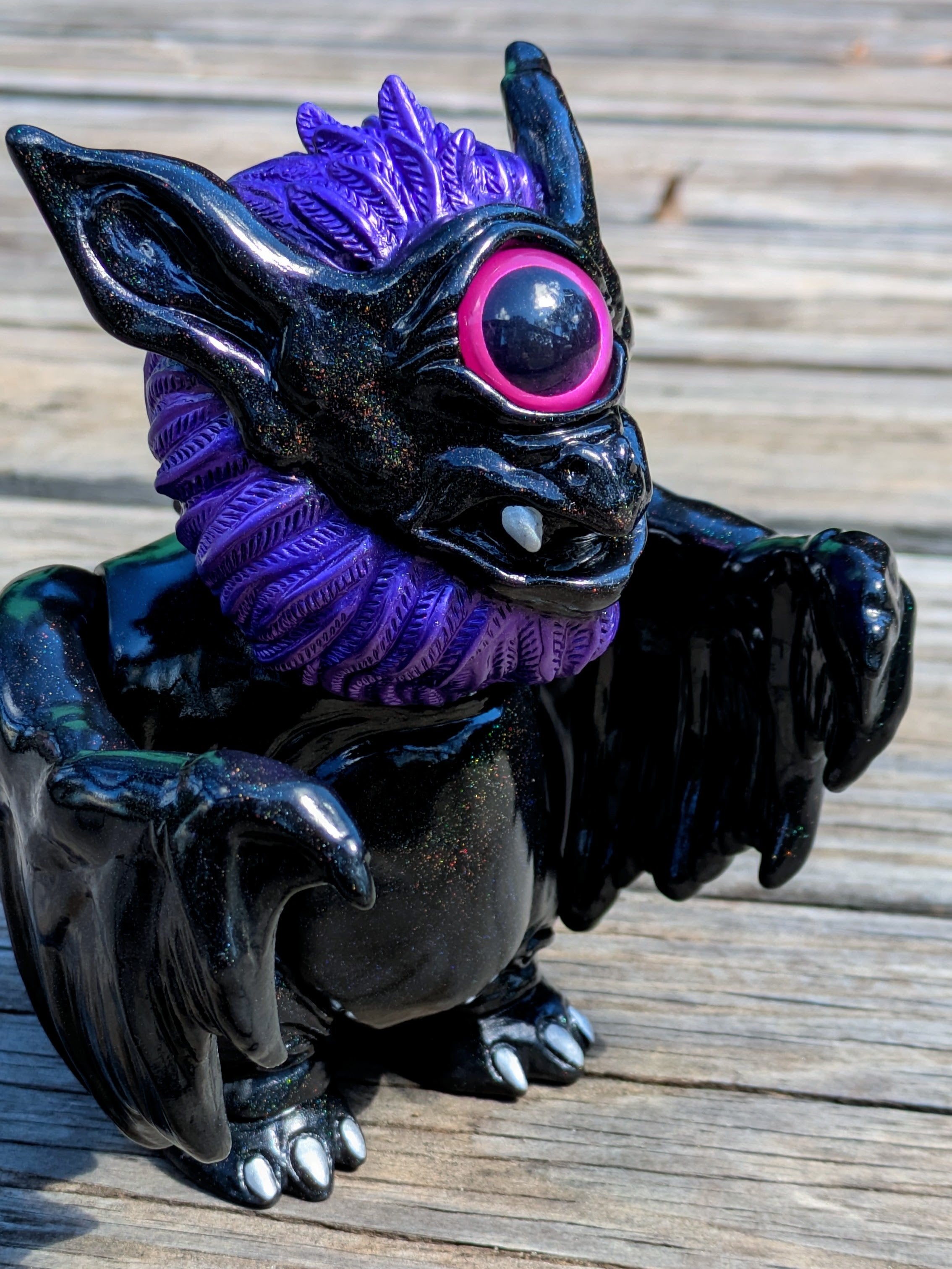 Present Sorcery - Goblidon by Wonder Goblin: A glossy, one-eyed, bat-like creature figurine with a pink-rimmed eye, purple mane, and small wings, includes a toy pouch.