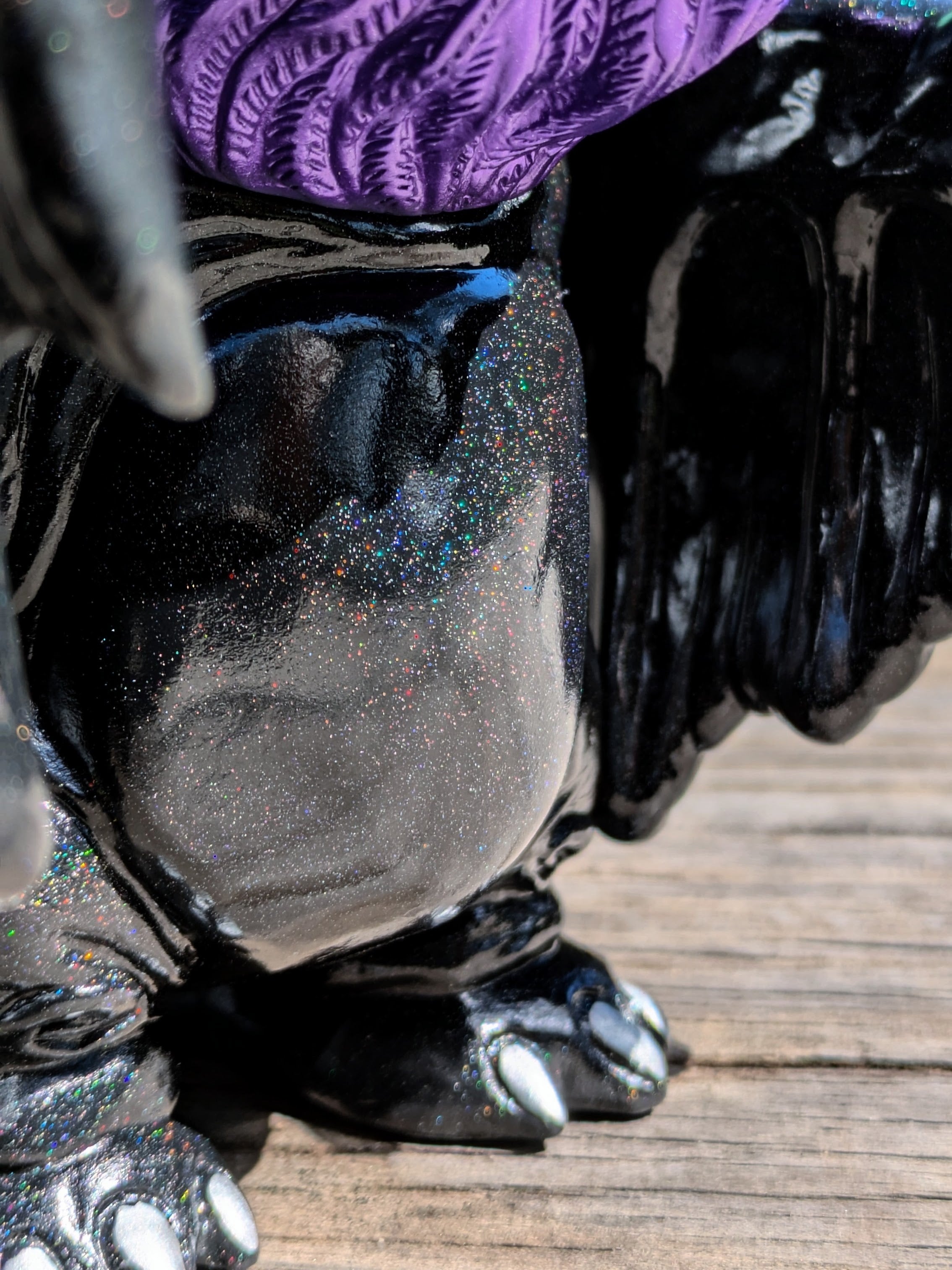 Close-up of 'Present Sorcery' Goblidon by Wonder Goblin, featuring a glittery black body, purple detail, and silver-tipped claws, characteristic of Strangecat Toys' art offerings.
