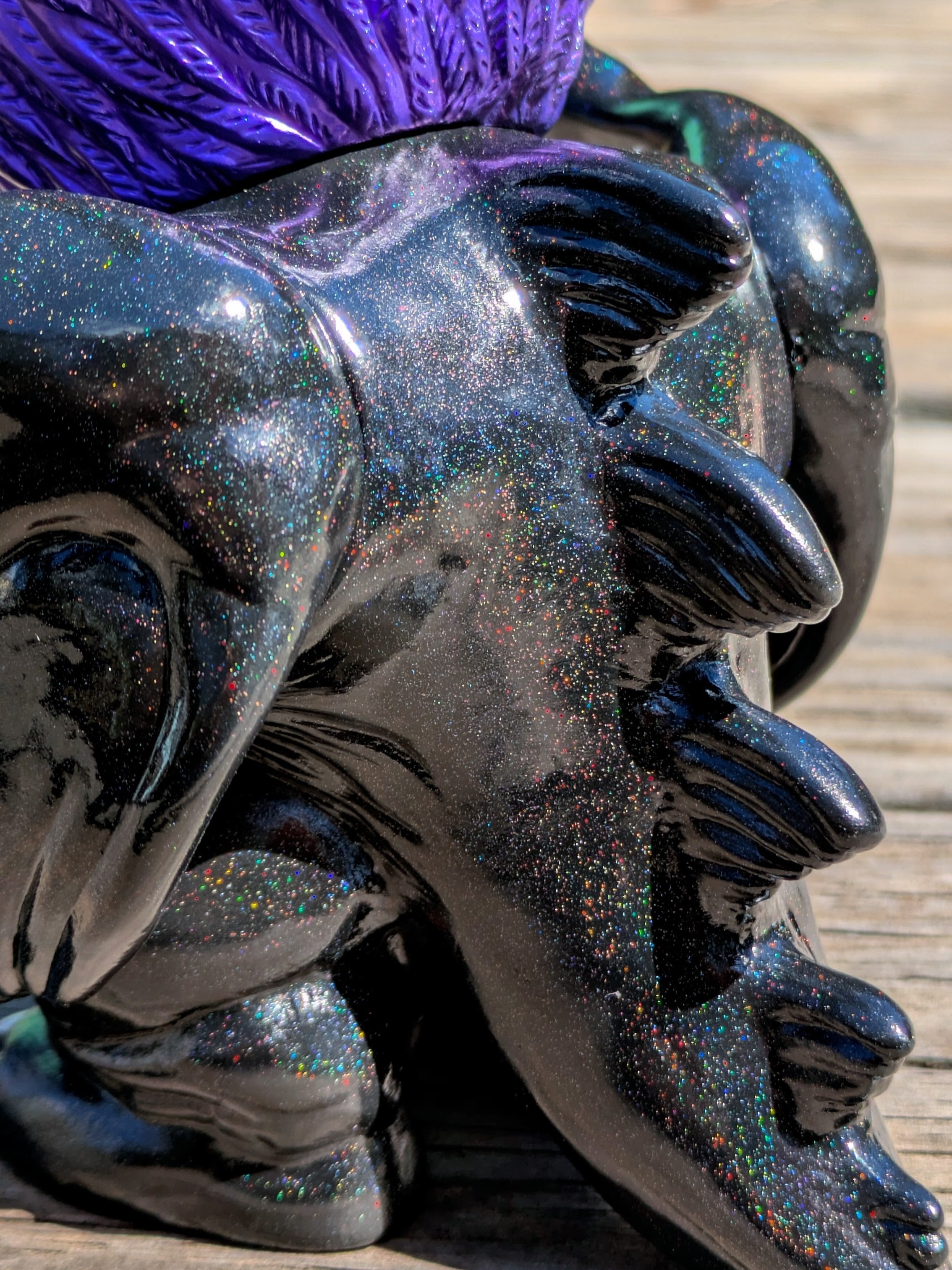 Close-up of 'Present Sorcery' - Goblidon by Wonder Goblin, a glossy black art toy with multicolored glitter, featuring claw-like protrusions and purple textured top.