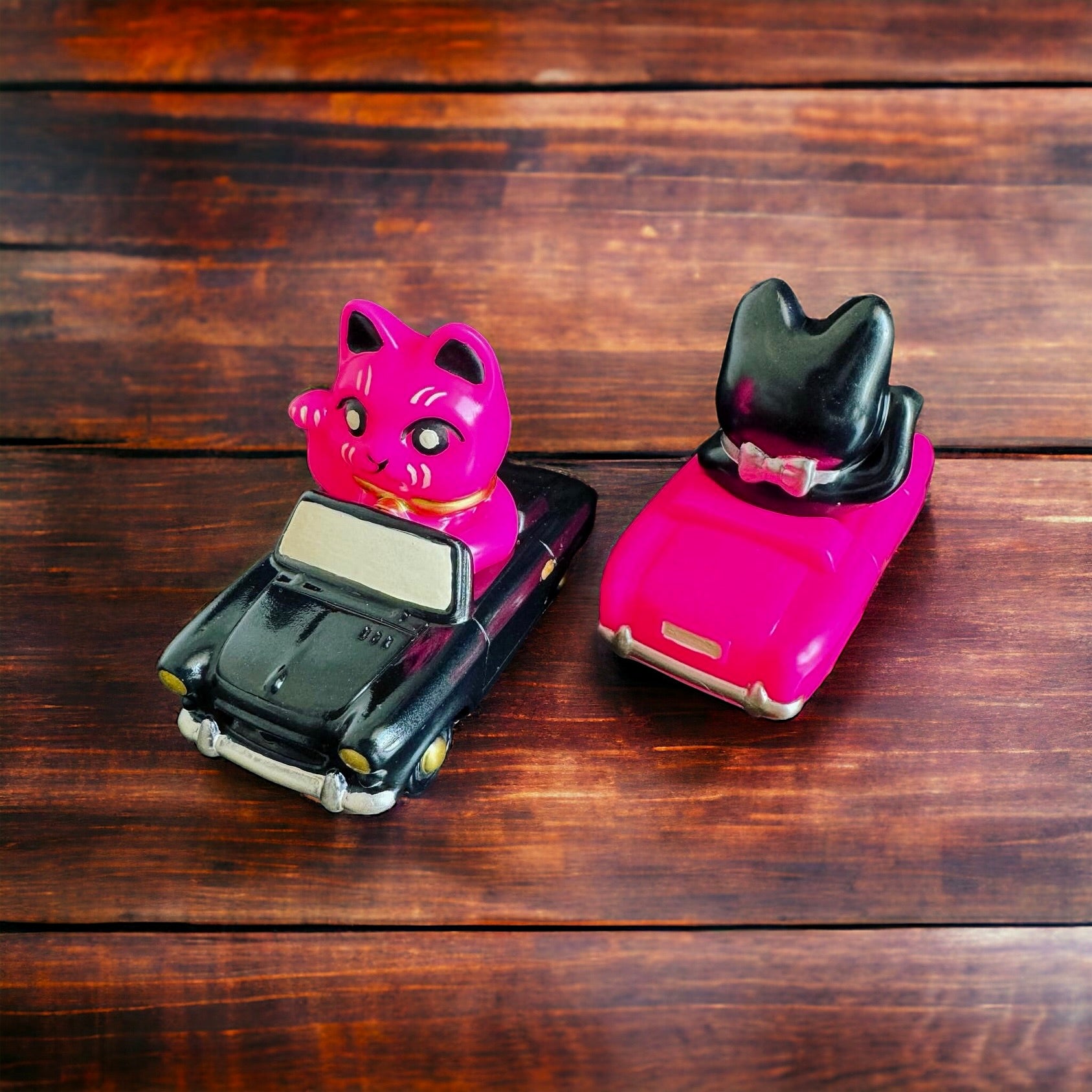 A vinyl Lucky Kitty Car toy on a wooden table, surrounded by toy cars and a cat figurine. Size: 7.5X.5cm. Blind Bagged. From Strangecat Toys.