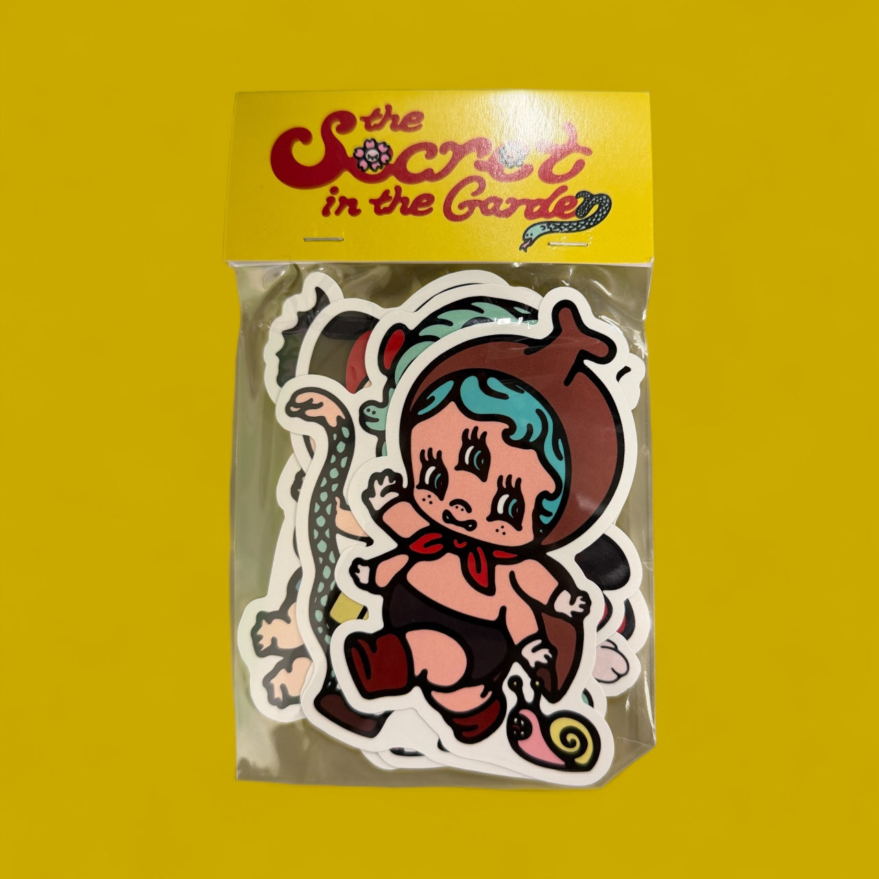 ABAO Garden sticker pack featuring retro-style die-cut vinyl stickers, including a cherub-faced child, snail, and garden motifs, inside a clear pouch with a yellow header.
